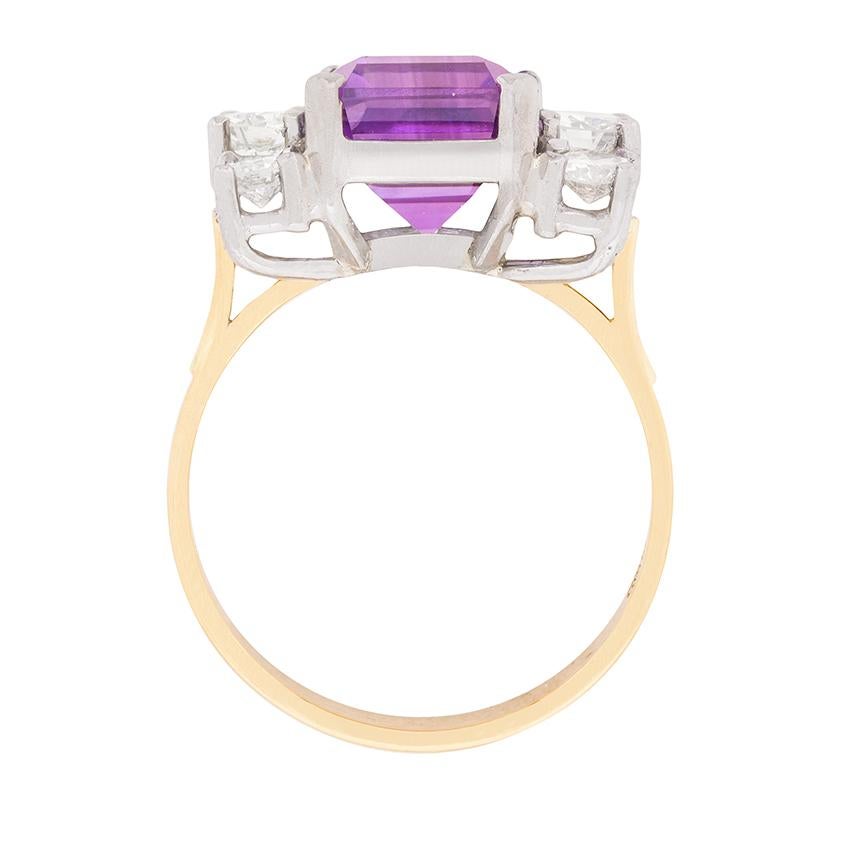 This beautiful ring has a show-stopping amethyst in the centre which is a wonderful purple. It weighs 7.80 carat and has been expertly claw set within an 18 carat white gold collet. Either side are three round brilliant diamonds, with the central