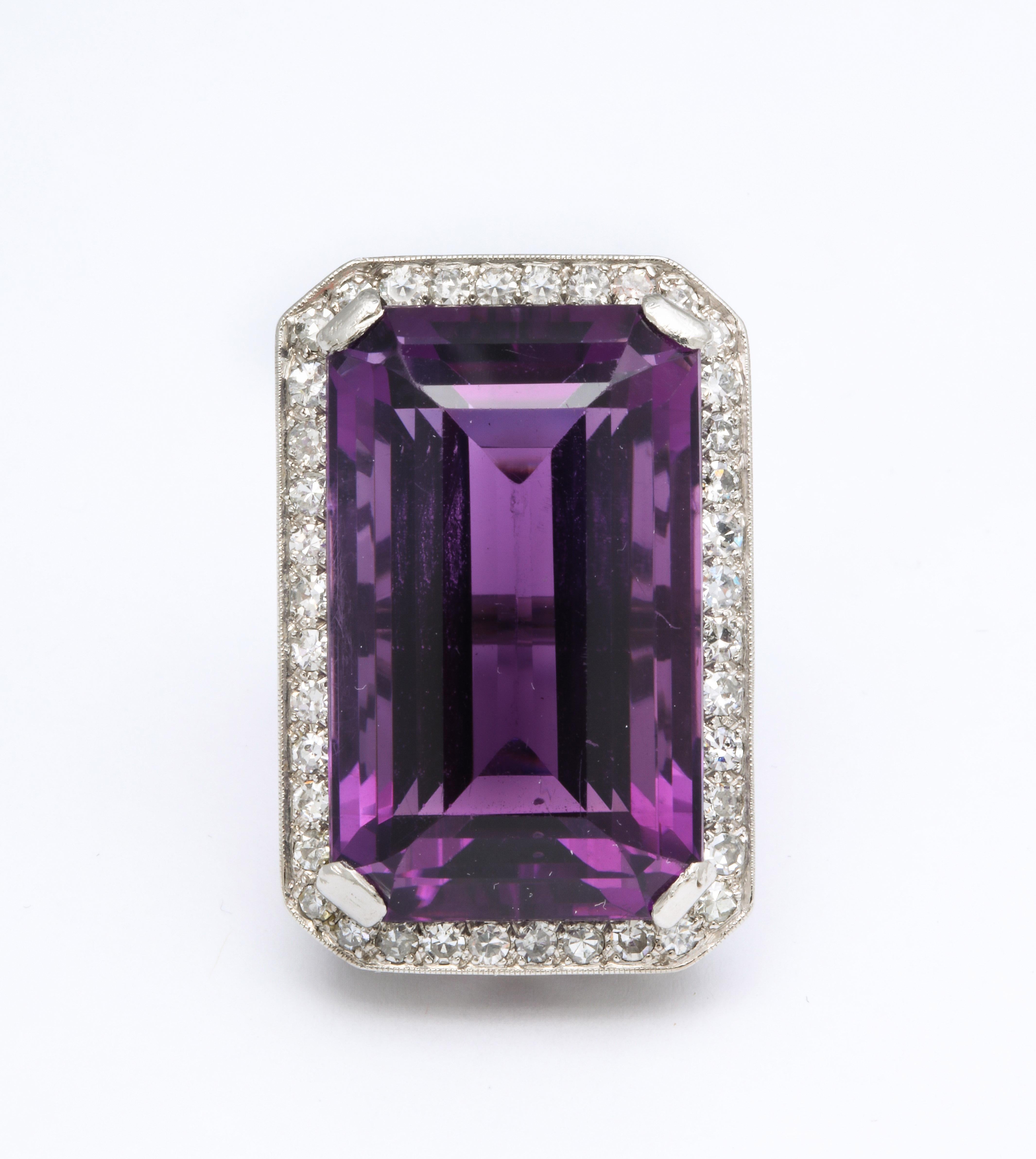 A great Vintage Amethyst and Diamond Platinum Ring. A great emerald cut deep 35 ct amethyst is surrounded by a frame of diamonds mounted on a pierced platinum ring.