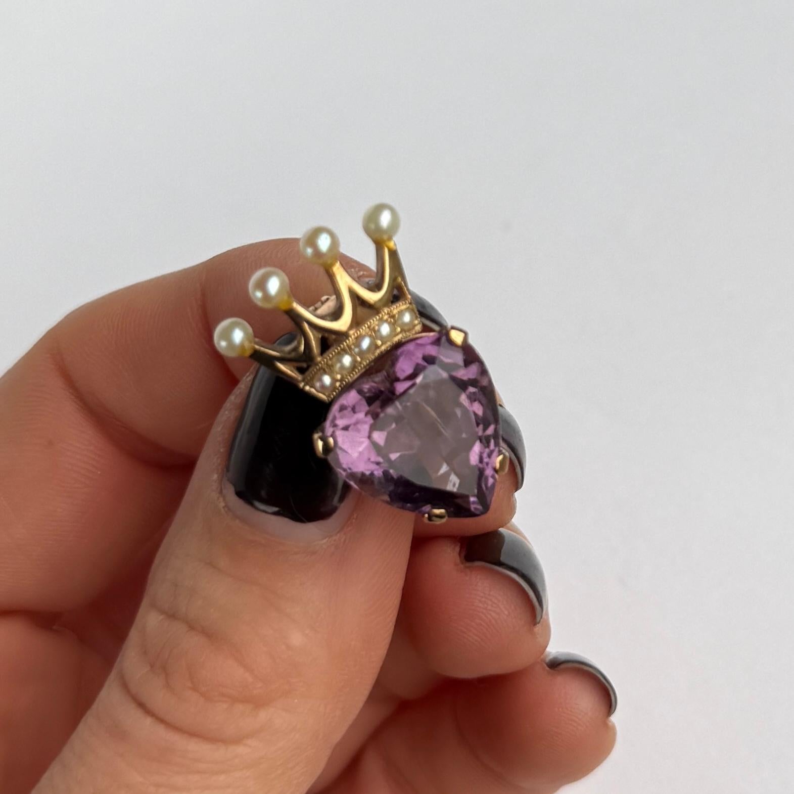 This gorgeous brooch holds a bright purple amethyst stone and a crown holding pearls. A Luckenbooth is a traditional Scottish love token often given as a wedding gift. The heart represents love and the crown is for loyalty. Modelled in 9 carat gold
