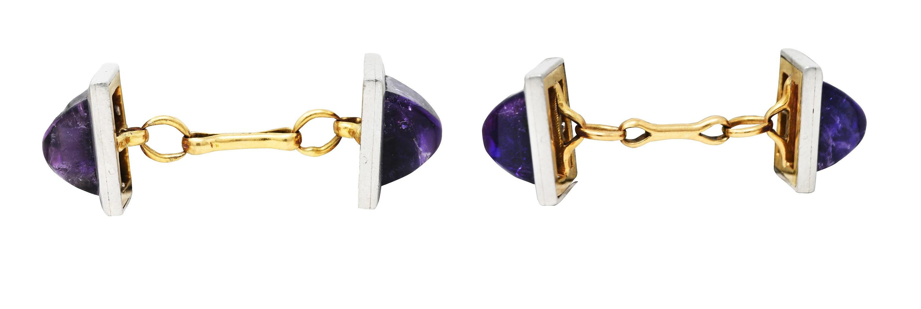 Link style cufflinks terminate as 11.5 mm square forms. Each centering an 8.5 mm highly domed sugarloaf cabochon of amethyst. Richly purple in color and translucent with natural inclusions. Surrounded by a platinum frame backed by yellow gold.
