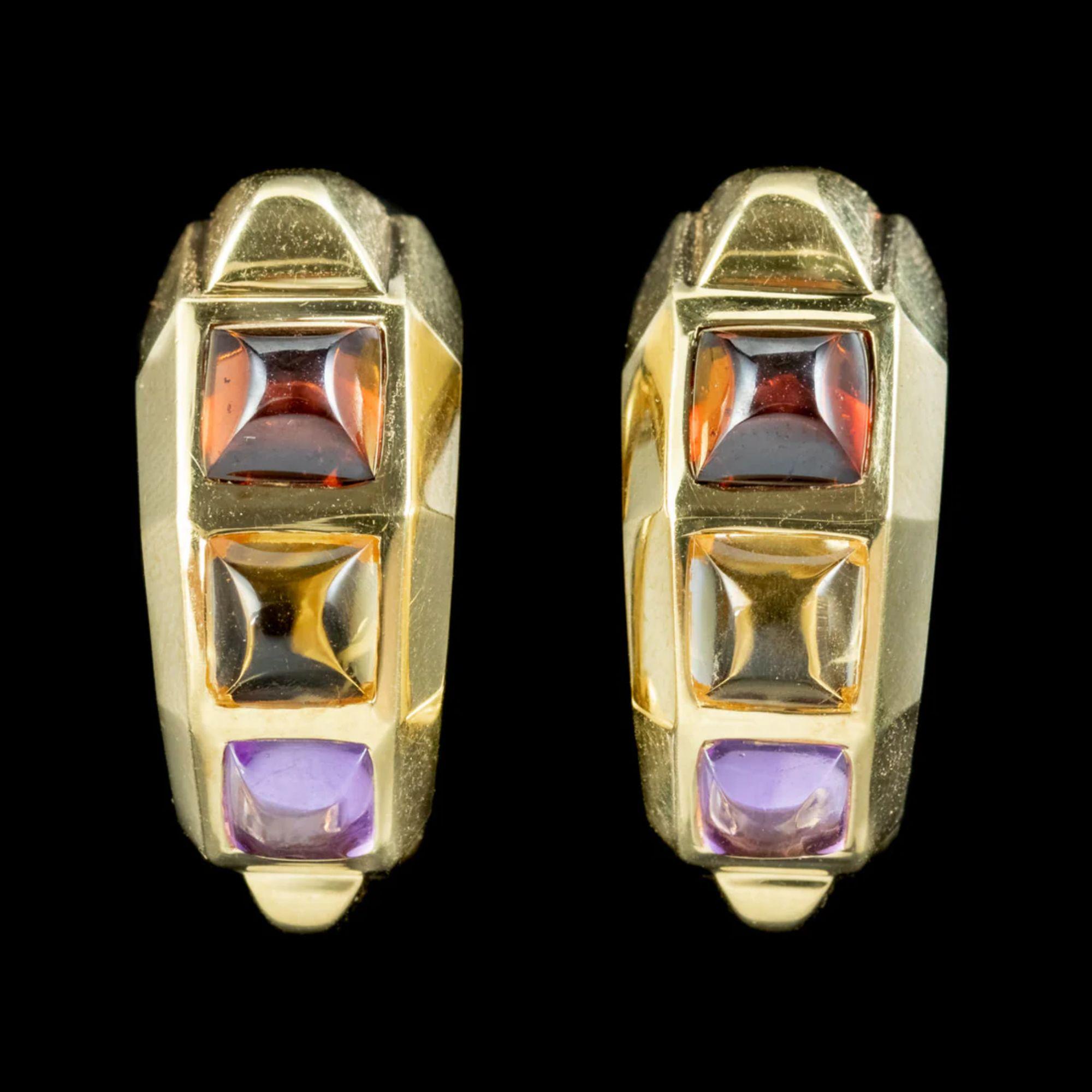 A colourful pair of vintage half hoop earrings decorated with square cabochon garnets, citrines and amethysts which are approx. 0.70ct each. 

Each earring is crafted in 18ct gold with a faceted, geometric design and secure lever back fittings at