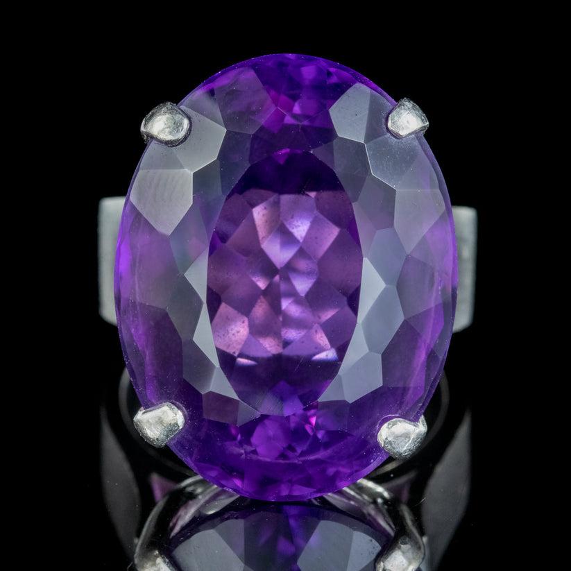 A spectacular Vintage cocktail ring boasting an enormous partial Briolette cut Amethyst held securely in a 14ct White Gold claw mount with a thick band complete with hallmarks.

The Amethyst has a vibrant purple hue and weighs an impressive 20ct