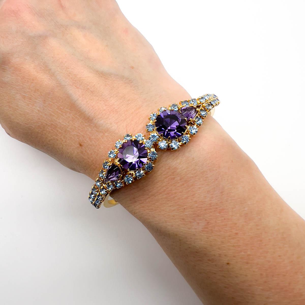 Un Clamper vintage de cristal de amatista. Inspirado en los diseños de brazaletes victorianos, el brazalete de cristal fue la respuesta de los años 50 al codiciado adorno antiguo. Adornada con divinos chatones de amatista y cristales en forma de