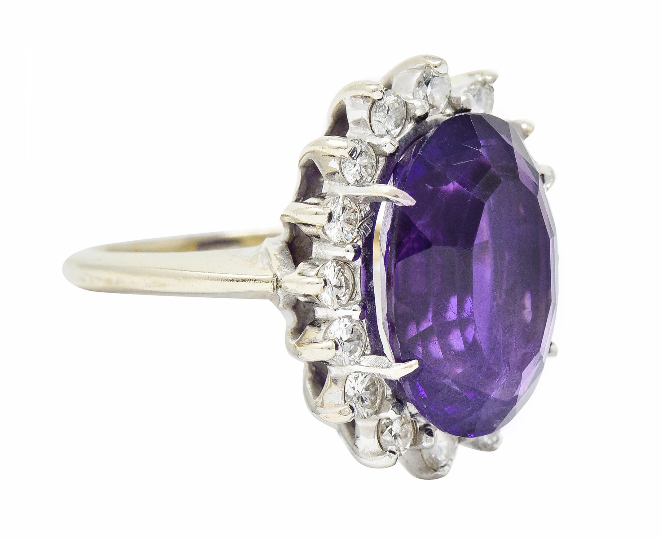Cluster style ring centers an oval mixed cut measuring approximately 14.1 x 10.0 mm

Transparent with medium-dark purple color; very saturated

With a halo of round brilliant cut diamonds weighing in total approximately 0.50 carat; G/H carat with VS