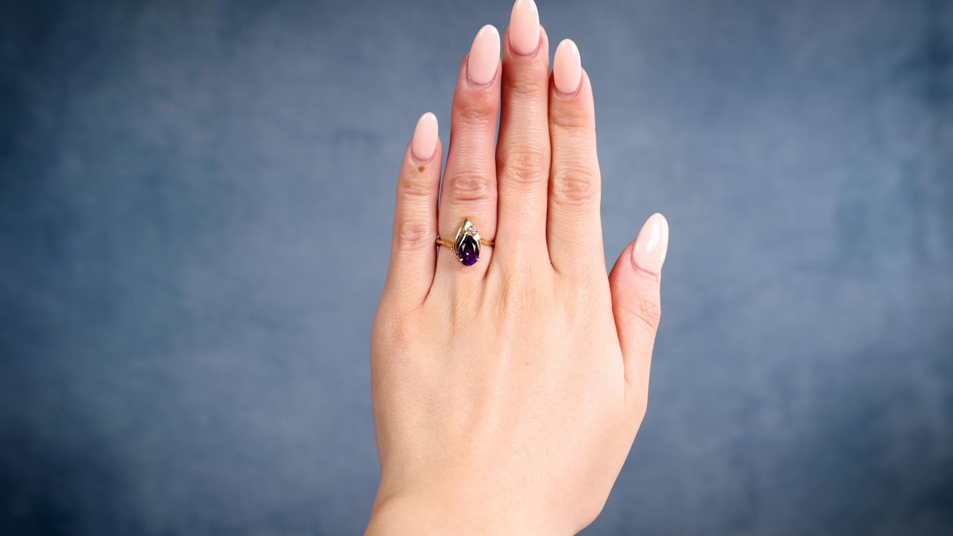 One Vintage Amethyst Diamond 14k Yellow Gold Ring. Featuring one pear brilliant cut amethyst weighing approximately 1.15 carats. Accented by one round brilliant cut diamond weighing approximately 0.05 carat, graded I color, SI1 clarity. Crafted in