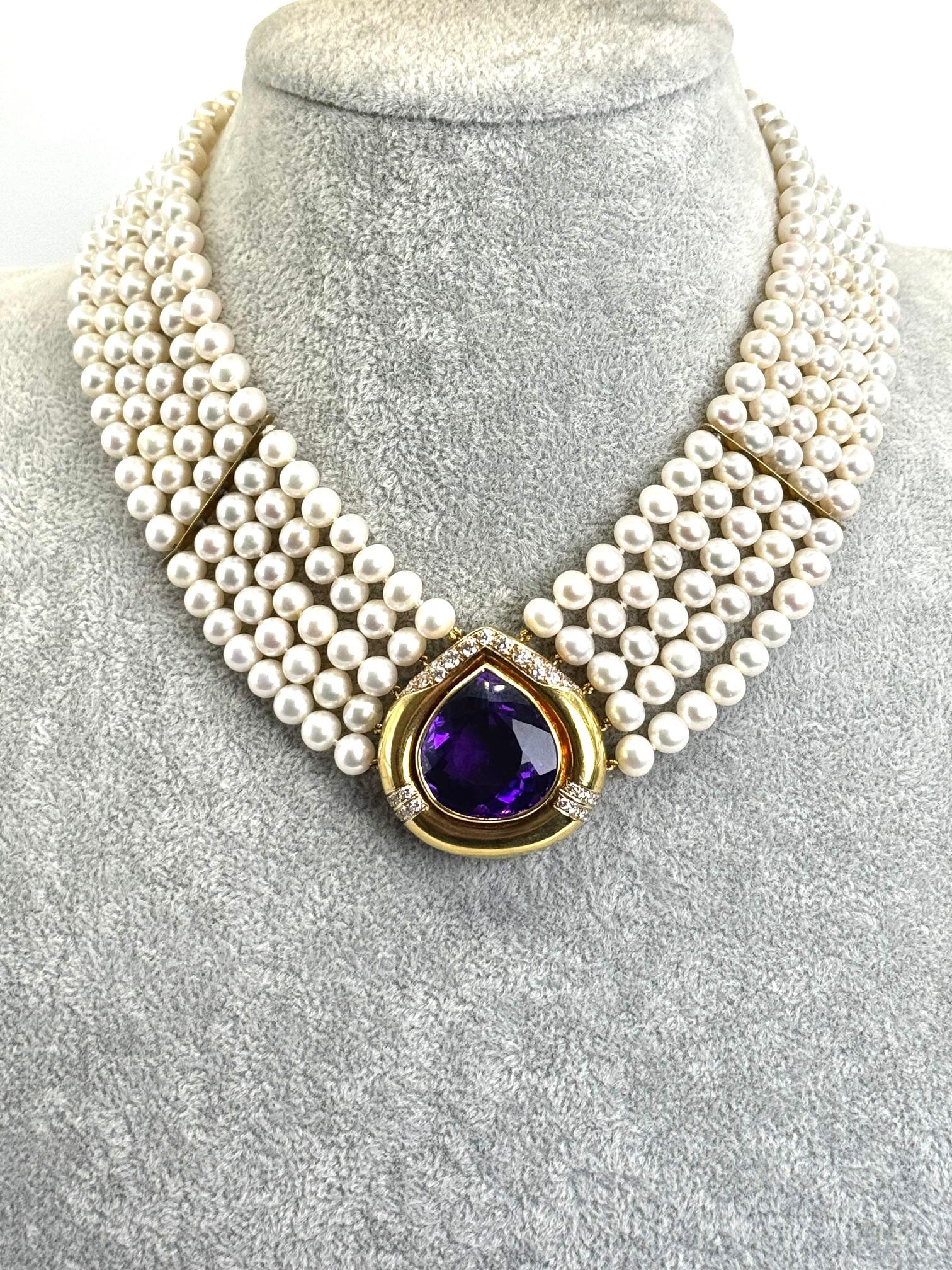 Questa collana vintage, un pezzo di grande effetto degli anni '90, presenta un lussuoso filo di cinque file di perle coltivate luminose, elegantemente strutturate con divisori in oro. Al centro si trova un'audace ametista a forma di pera del peso di