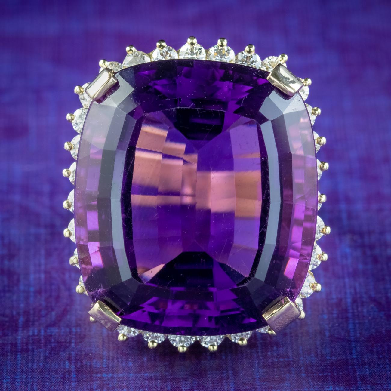 Boasting an enormous cushion cut amethyst, this spectacular cocktail ring was made to be seen! The amethyst weighs an impressive 40 carats (approx.) and has a luxurious, deep purple hue and an array of glistening facets, complemented beautifully by