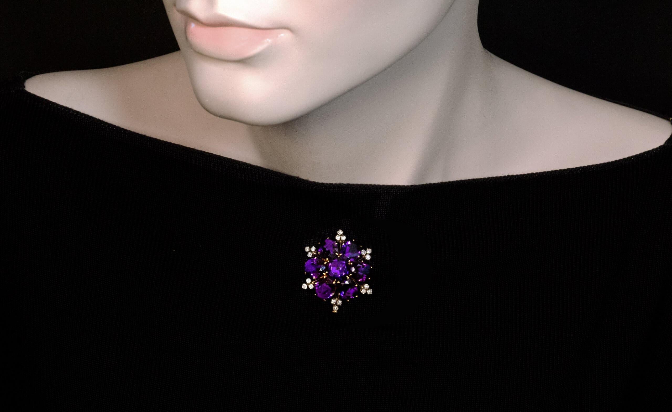 made in Vienna, Austria, circa 1925.
The brooch is designed as a stylized flower head. It is finely crafted in 18K yellow and white gold. The brooch features seven amethysts of excellent deep purple color accented by small single cut diamonds. The