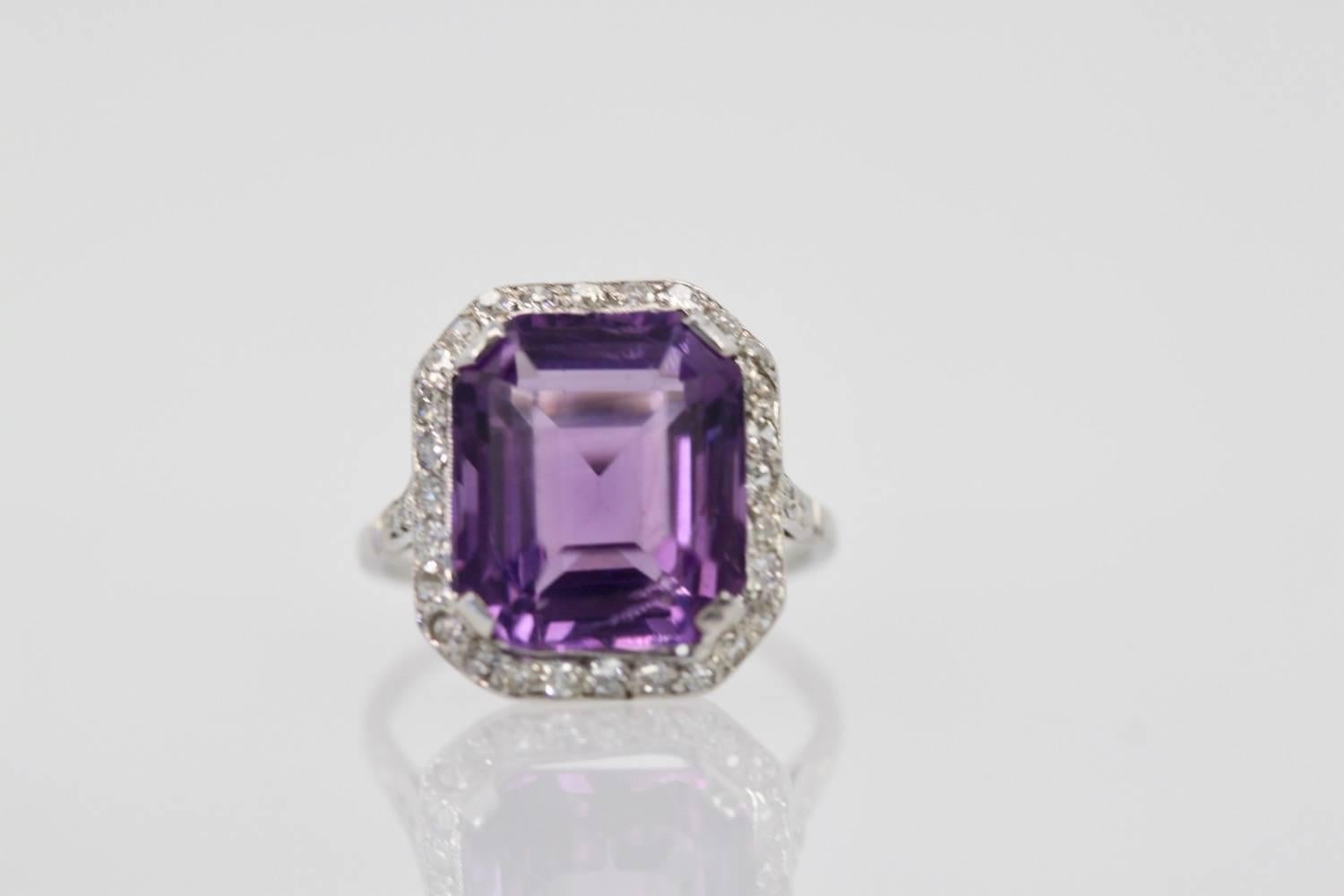This Vintage Amethyst ring centers on a large 9.44 Carat Amethyst with a Diamond surround and border with 32 old cut diamonds G-I, SI Clarity. This ring was made around 1930 and is set in Platinum.  Lovely size 5.5 can be enlarged and weights 5.4