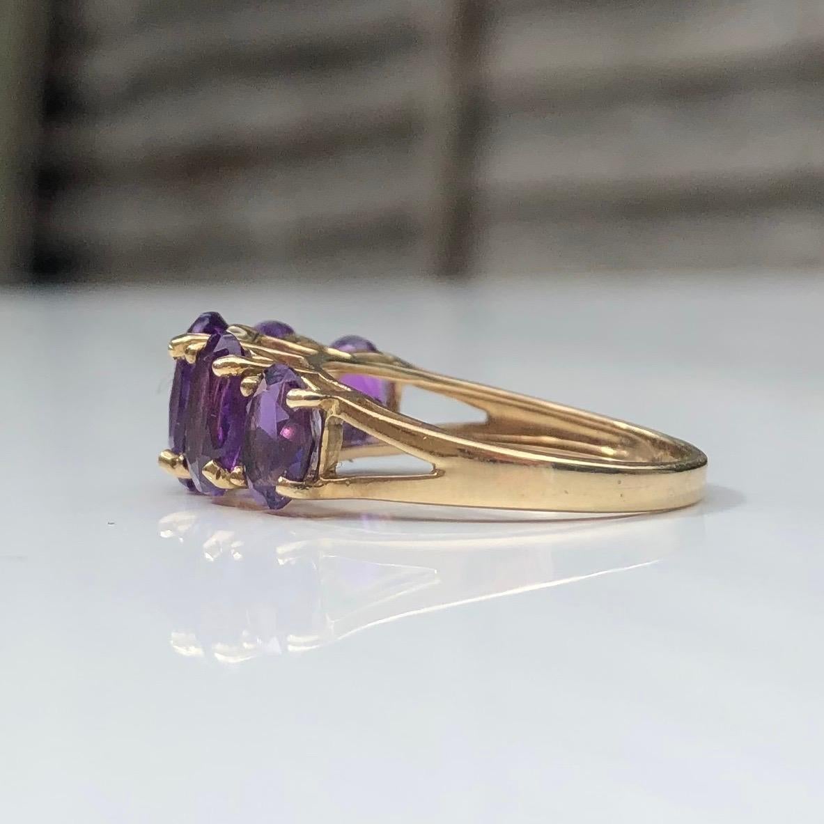 The five bright amethyst stones set in this ring are set up high on a simple openwork gallery. The ring is modelled in 9ct gold and made in Birmingham, England. 

Ring Size: L or 5 3/4
Band Width (widest point): 8mm
Height Off Finger: 6mm

Weight: