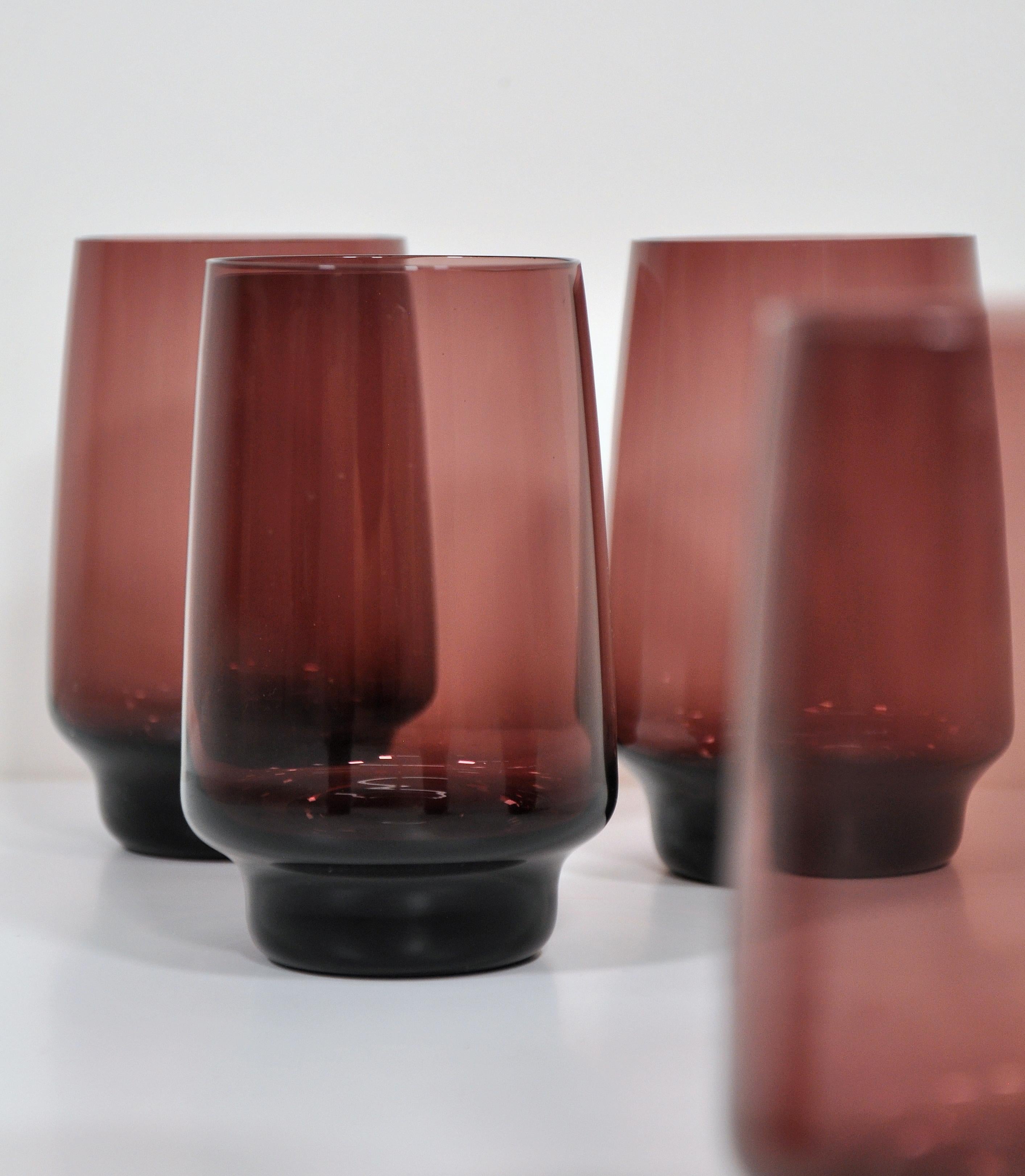 Vintage hand blown glass cocktail set including a carafe and 6 shaped stacking tumbler glasses in a gorgeous plum color. The footed jug features a clear glass handle and pinched spout. The glasses and set as a whole have a clean and modern aesthetic