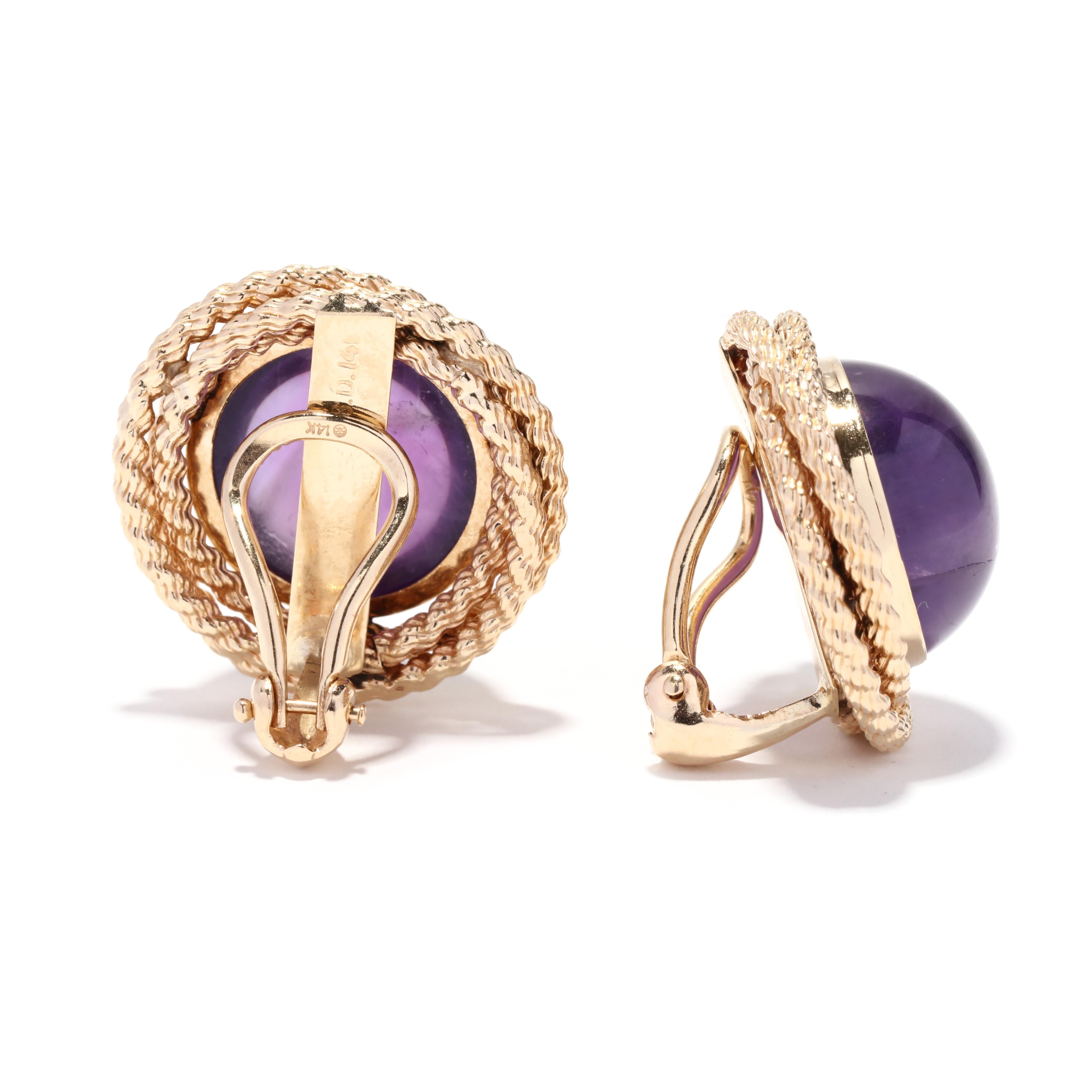 A pair of vintage 14 karat yellow gold amethyst knot clip on earrings. These earrings feature bezel set, round cabochon cut amethyst stones weighing approximately 23 total carats with a twisted rope motif border and with omega clip backs.

Stones:
-