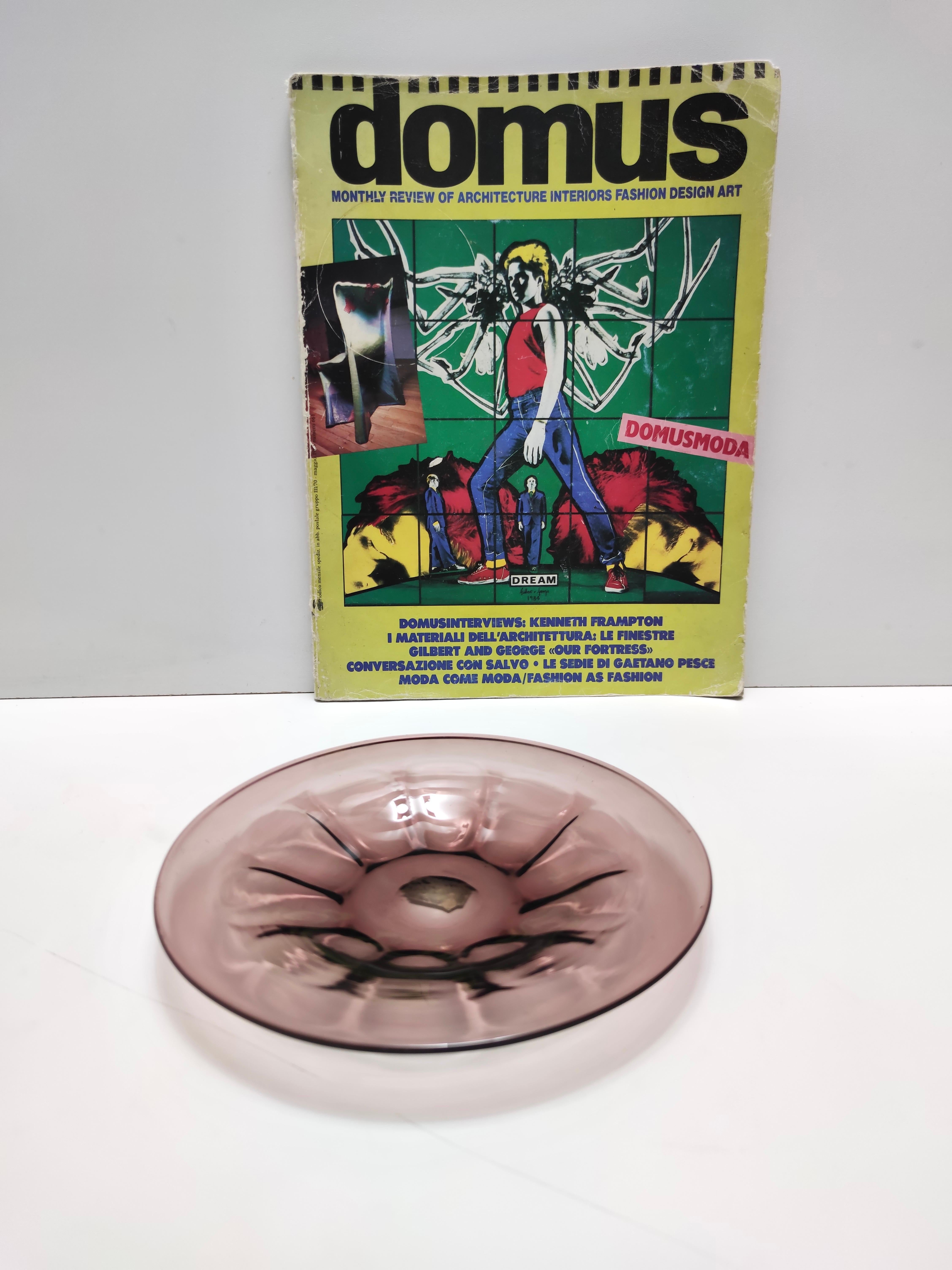 Realizzato in Italia, anni '20. 
Questa ciotola portagioie / vide-poche è realizzata in vetro di Murano a coste color ametista.
Potrebbe presentare lievi tracce d'uso, ma può essere considerato in ottime condizioni originali e pronto a diventare un