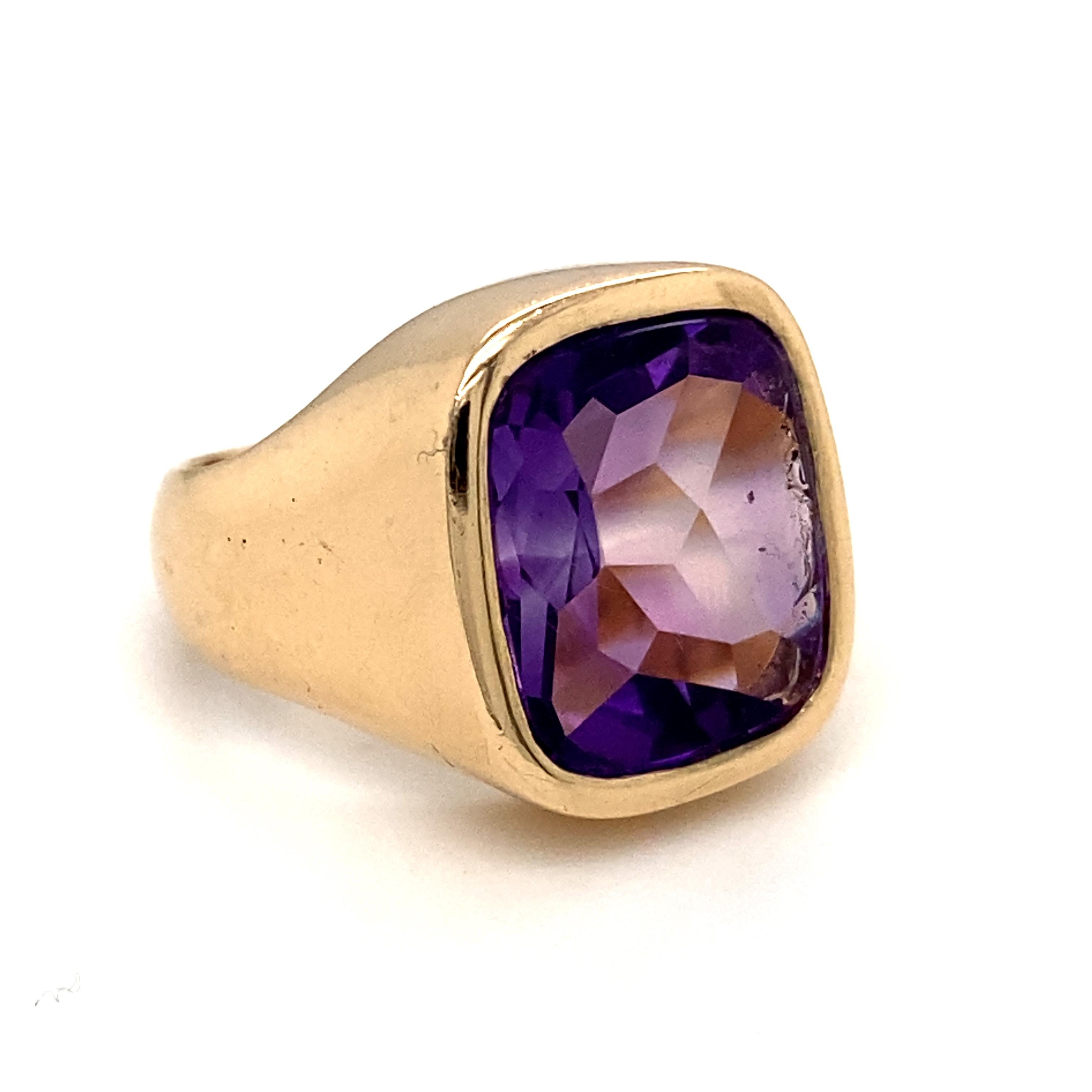 A vintage amethyst signet ring in 14 karat yellow gold, circa 1980.

Formed as a cushion shape, and set with a faceted deep purple amethyst within a plain polished bezel to wide sloping gently curving shoulders.

This ring, is incredibly comfortable
