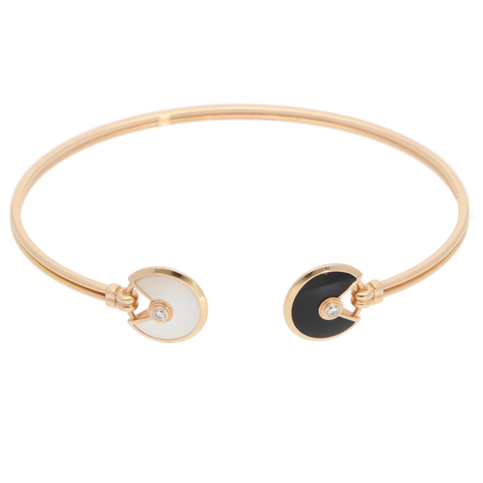 A beautiful vintage Amulette de Cartier open bracelet set in 18k rose gold with mother-of-pearl, onyx and diamond.

The bracelet features the iconic Cartier's Amulette motif. Each motif is centrally set with a round brilliant-cut diamond in bezel