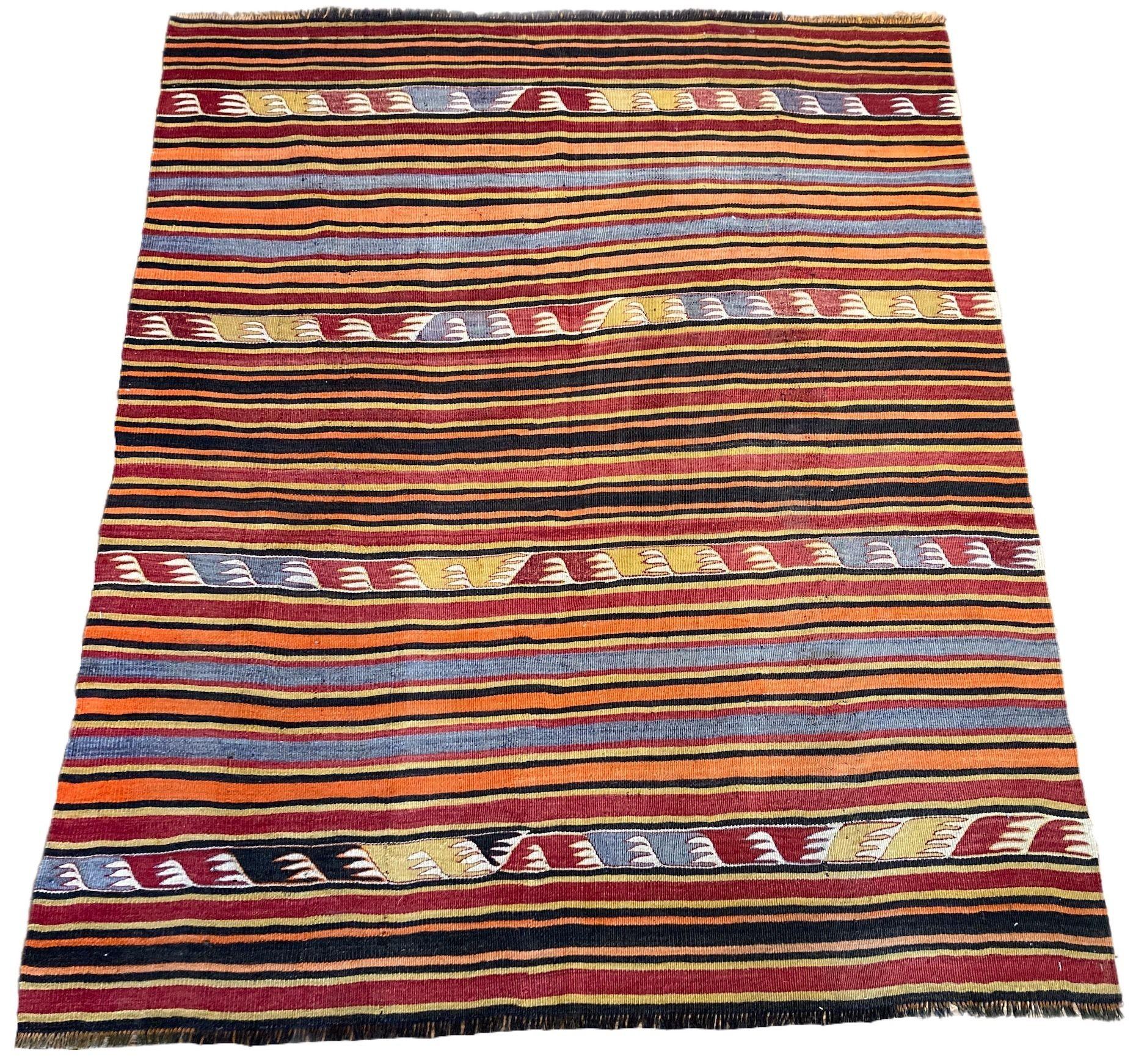 A lovely vintage kilim, handwoven in central Turkey circa 1960 featuring a multicoloured banded design in reds, terracottas, blues and golds.
Size: 1.70m x 1.42m (5ft 7in x 4ft 8in)
This kilim is in good condition with light, age related wear. The
