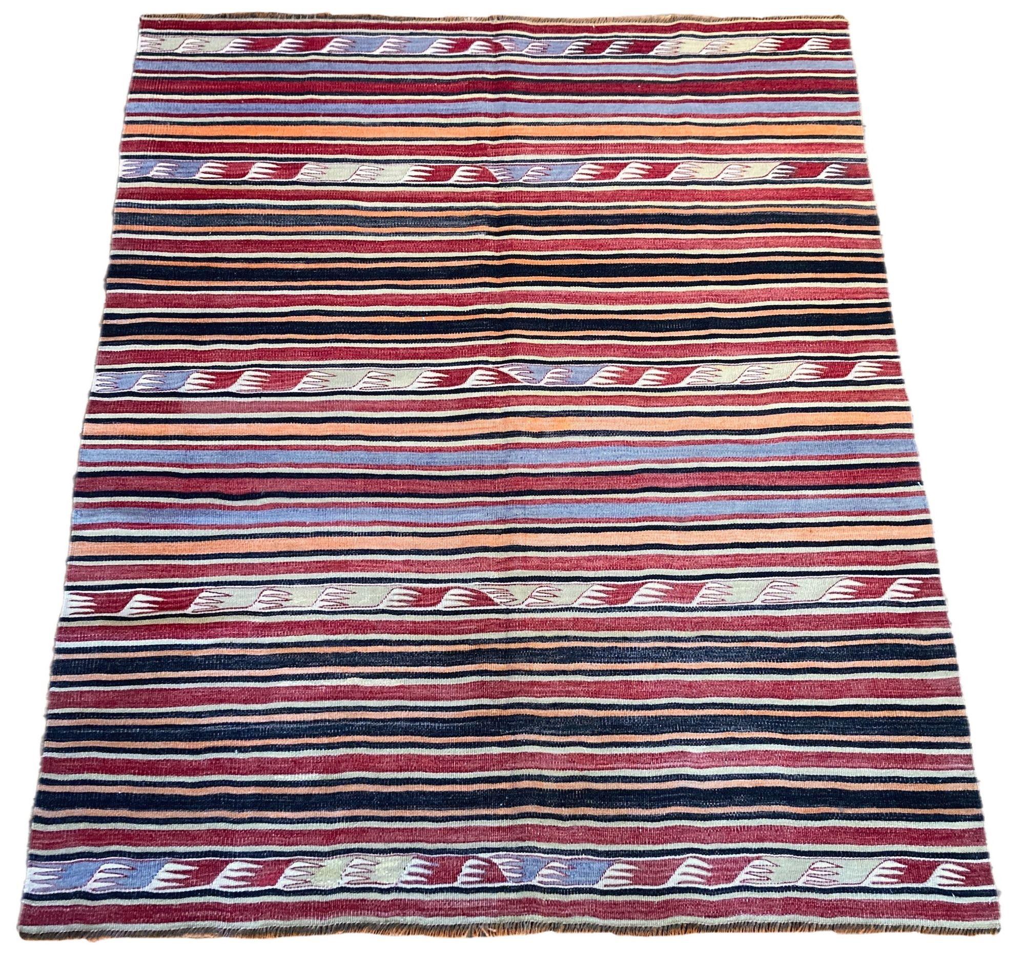 A lovely vintage kilim, handwoven in central Turkey circa 1960 featuring a traditional multicoloured banded design in reds, blues and golds.
Size: 1.80m x 1.51m (5ft 11in x 5ft)
This kilim is in good condition with light, age related wear. The