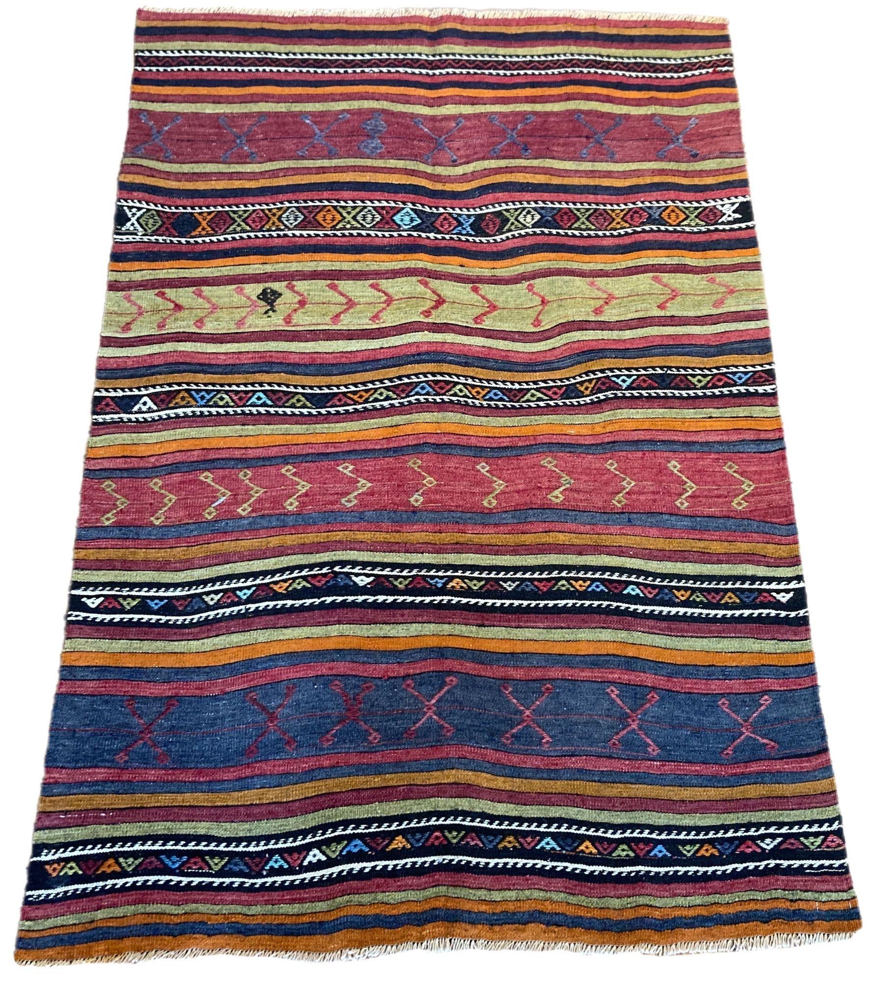 A lovely vintage kilim, handwoven in central Turkey circa 1960 featuring a multicoloured banded design in blues, reds, greens and golds.
Size: 1.97m x 1.33m (6ft 6in x 4ft 4in)
This kilim is in good condition with light, age related wear. The