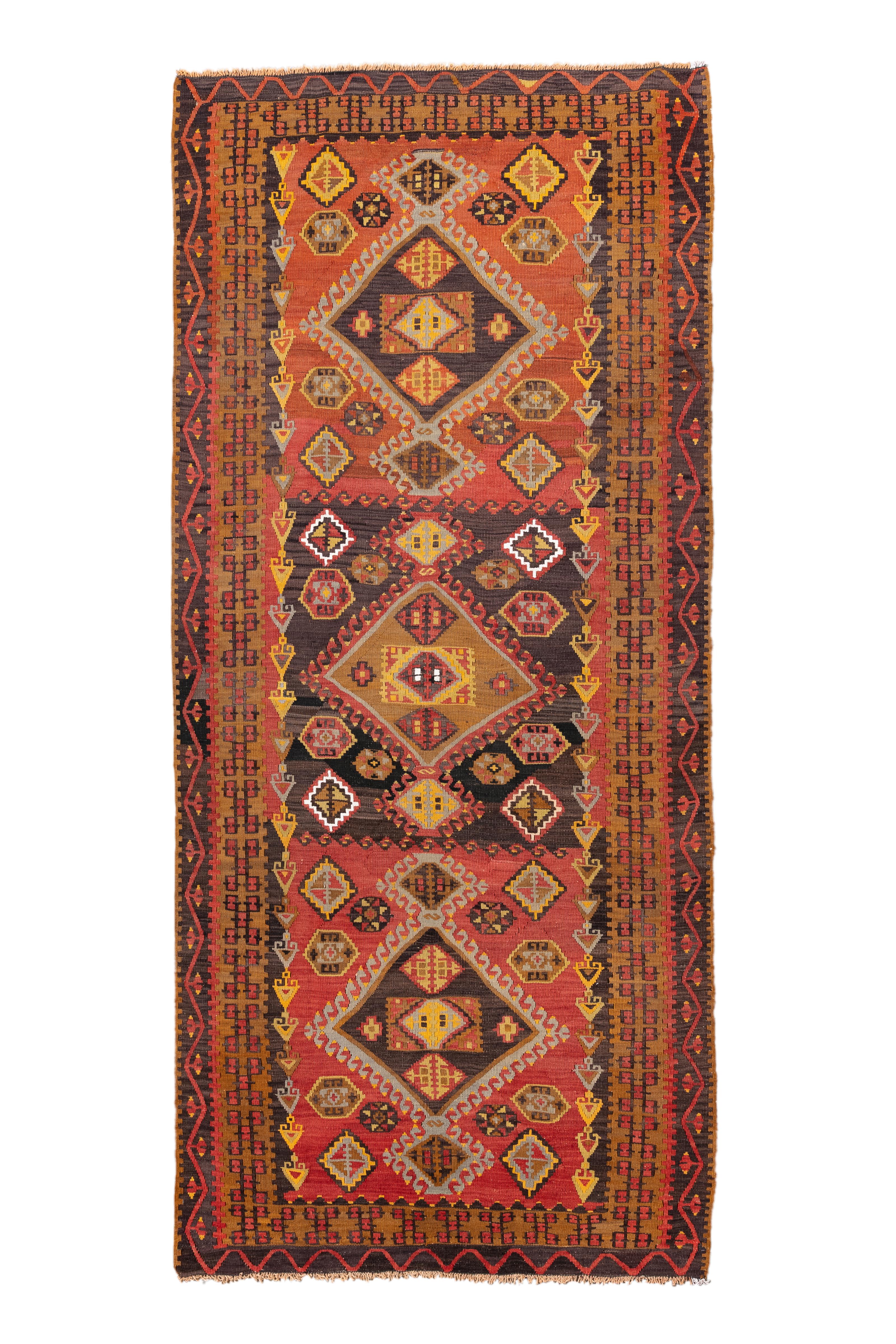 Audace, espressivo e dai colori vivaci, questo tappeto vintage Rug & Kilim dell'Anatolia presenta un'impressionante visualizzazione di forme geometriche in una disposizione a scala di medaglioni. I toni profondi della ruggine, dell'ocra e del
