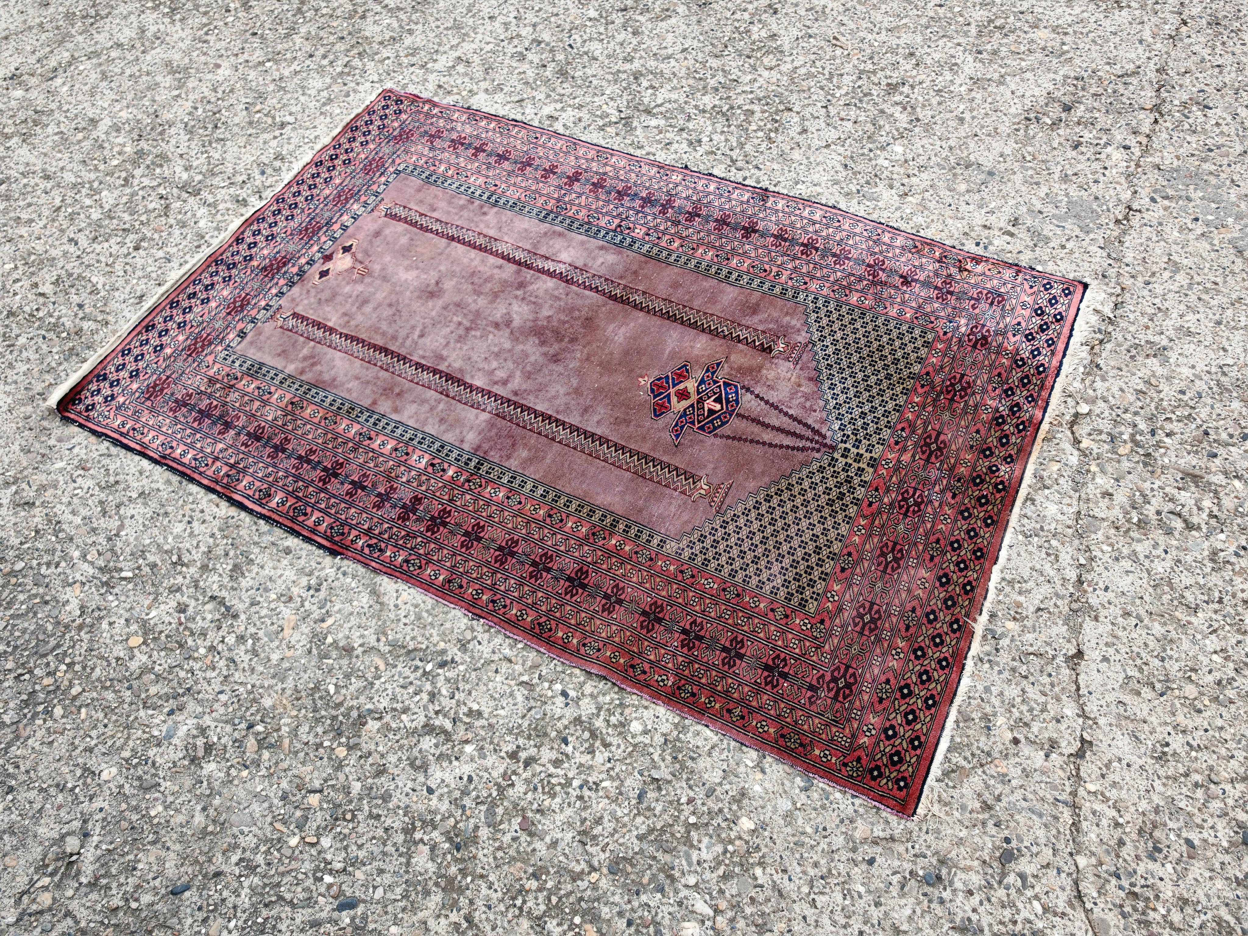 In diesem Angebot finden Sie einen wunderschönen handgewebten Gebetsteppich, der von anatolischen Stämmen in der Türkei hergestellt wurde. Der Teppich zeigt religiöse Motive und ist aus violetter und grauer Wolle gefertigt, was bei Vintage-Teppichen