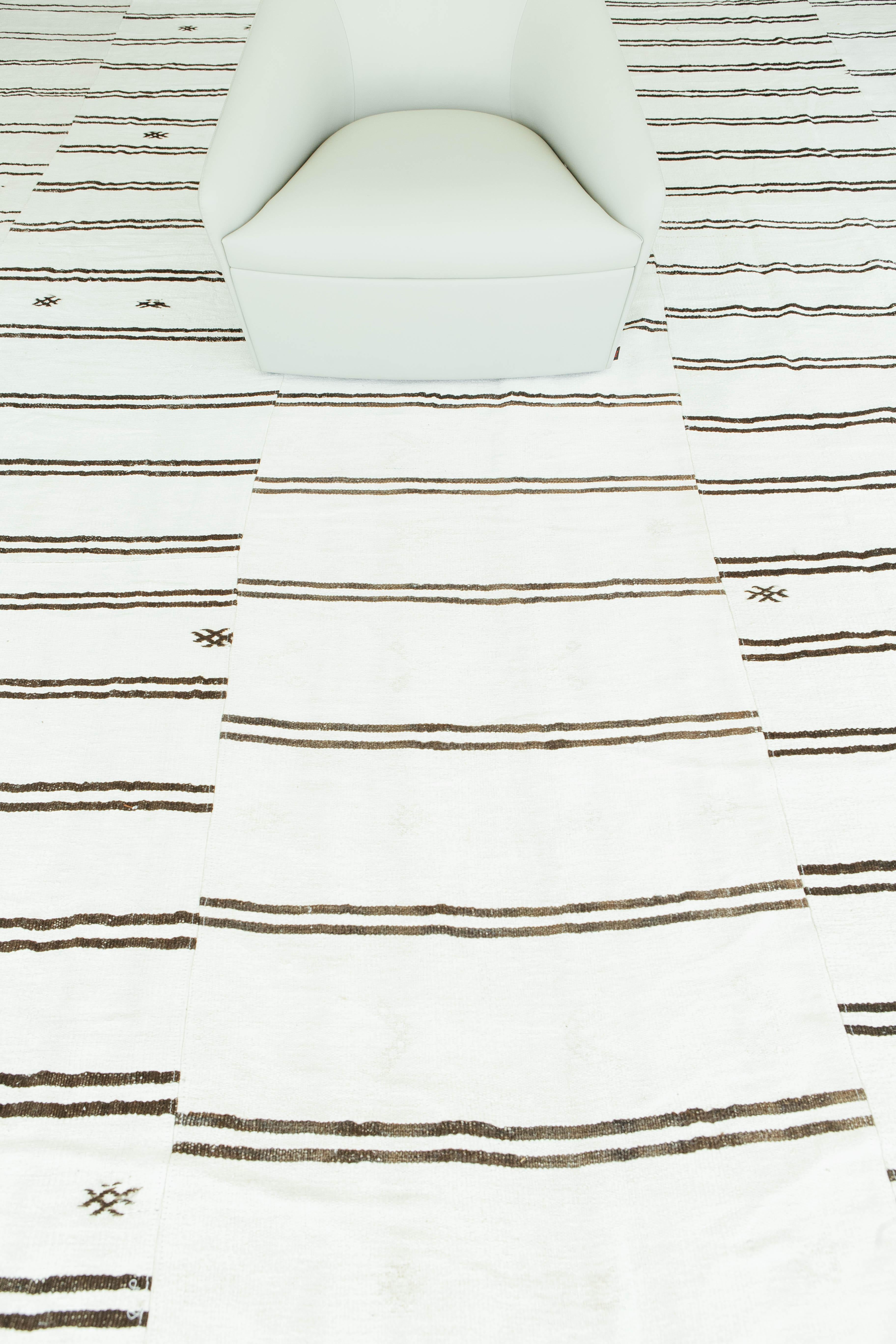 A gorgeous vintage Anatolian Turkish flat-weave banded in ivory and irregular brown stripes. Sporadic tribal designs and varying degrees of stripes create a simple yet interesting design for a wide variety of interiors. Vintage Turkish Anatolian
