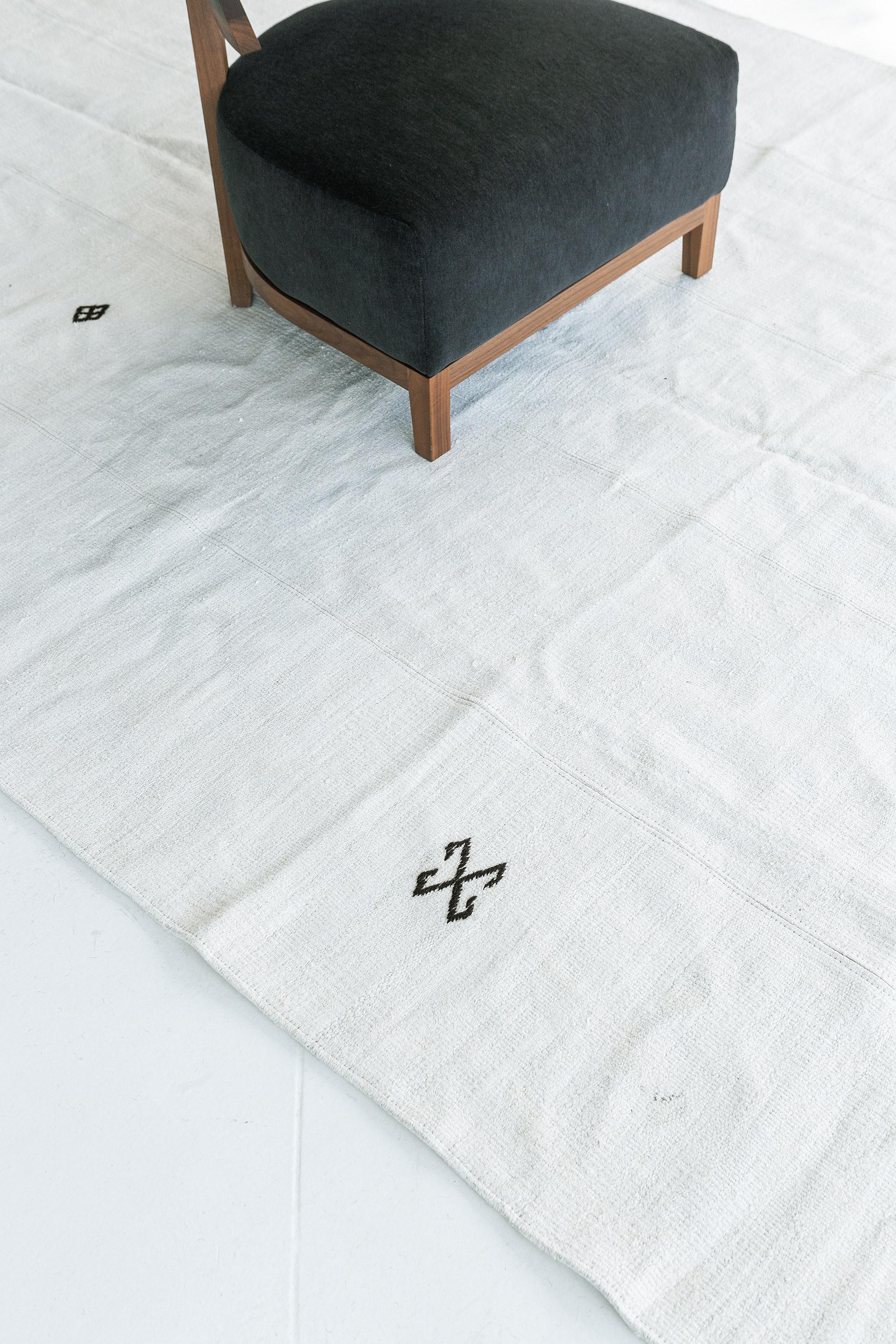 Dieser bemerkenswerte anatolische Teppich ist ein bescheidener, weißer Flachgewebe-Teppich, der Leben und Licht in den Raum bringt. Das Design ist mit vier lebendigen Symbolen durch den Hanfflor gestaltet. Anatolian wurde entwickelt, um auch bei