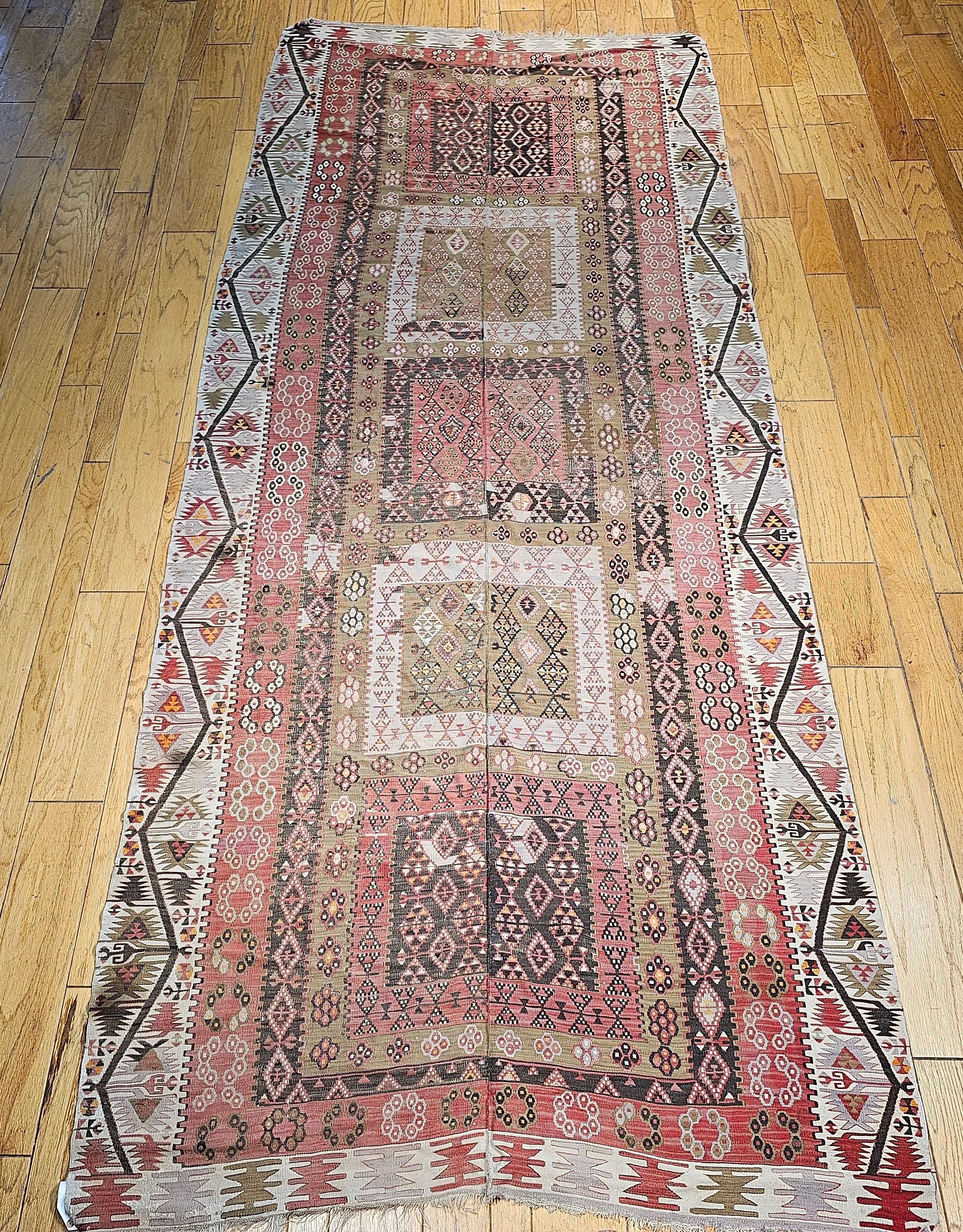 Vintage Turkish gallery rug or a wide runner flat woven kilim from the early 1900s.  The kilim has beautiful soft colors including pale brick red in the field which is formed by 5 large rectangular medallions in a column in different colors and