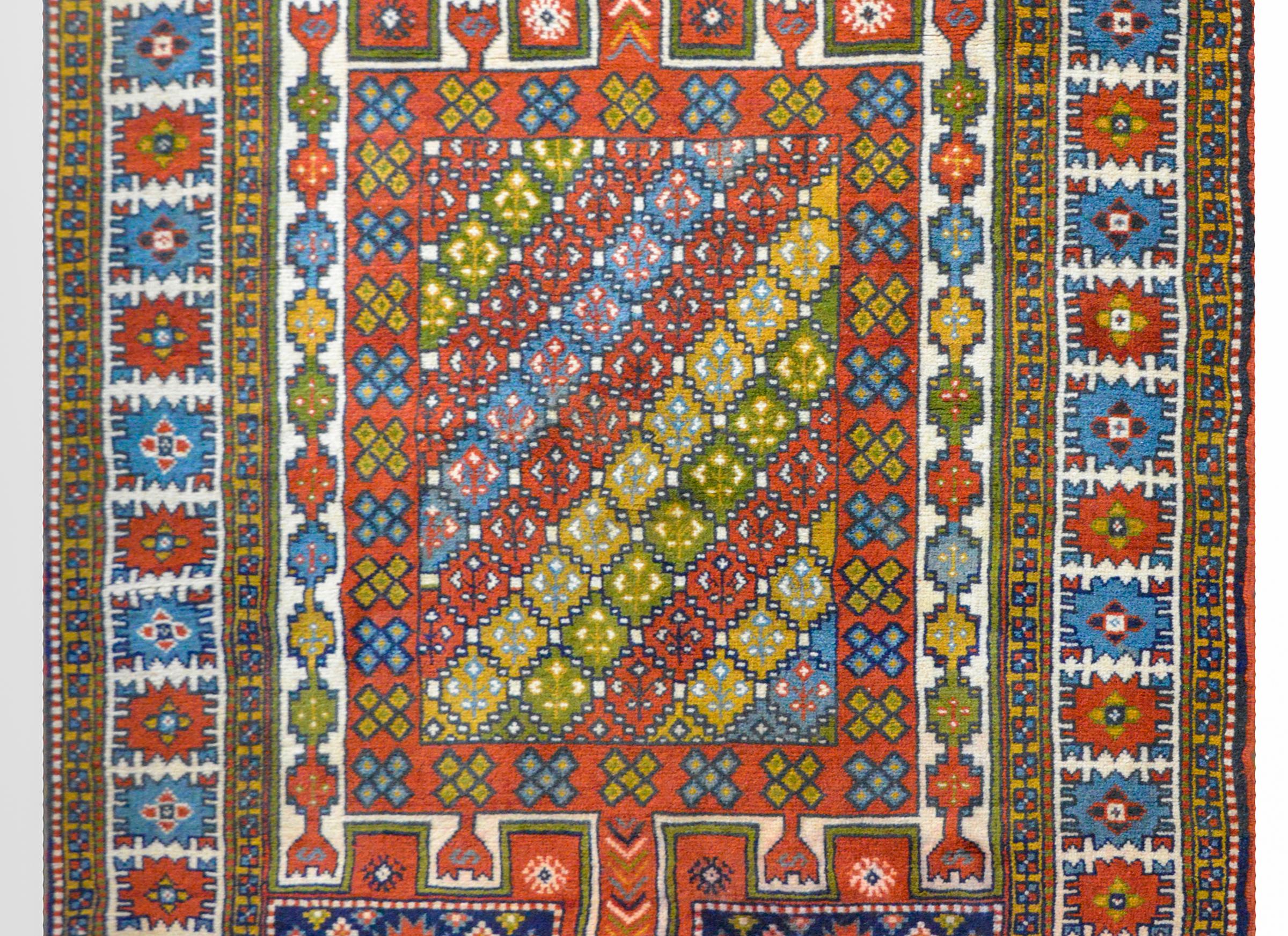 An Anatolian Turkish prayer rug with a fantastic stylized floral and geometric pattern woven in myriad primary colors including indigo, crimson, gold, and green, against a white background. The border is wonderful with a large stylized floral