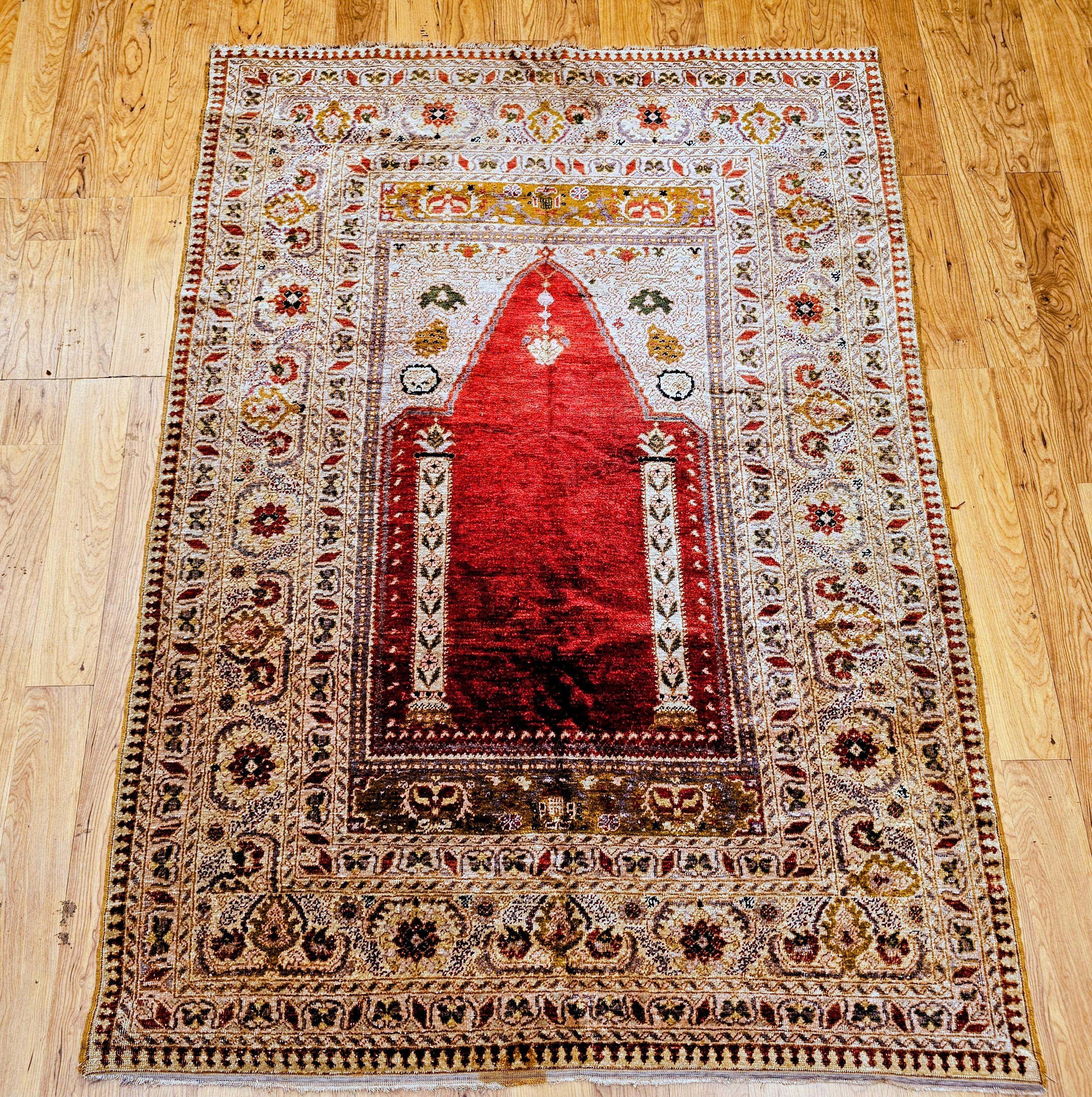Dieser prächtige türkische Gebetsteppich aus dem späten 19. Jahrhundert aus reiner Seide im traditionellen Mihrab-Design ist ein Beispiel für die meisterhafte Kunst der osmanischen Seidenweberei. Der vollständig aus glänzender Seide handgewebte