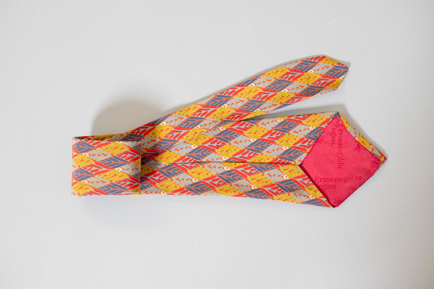 Elegant mid-century tie of Italian manufacture. It is made of 100% silk. Decorated with small colored rhombuses created from small geometric shapes. Perfect to combine with both jeans and an elegant suit. 