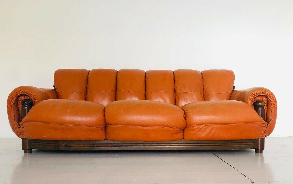 This rare sofa and armchairs set is a design furniture realized in Brasil in the 1970s.

It is a unique item including a three-seat sofa and two armchairs; with an ash structure with seat and back covered in light brown leather.

Dimensions: 
-