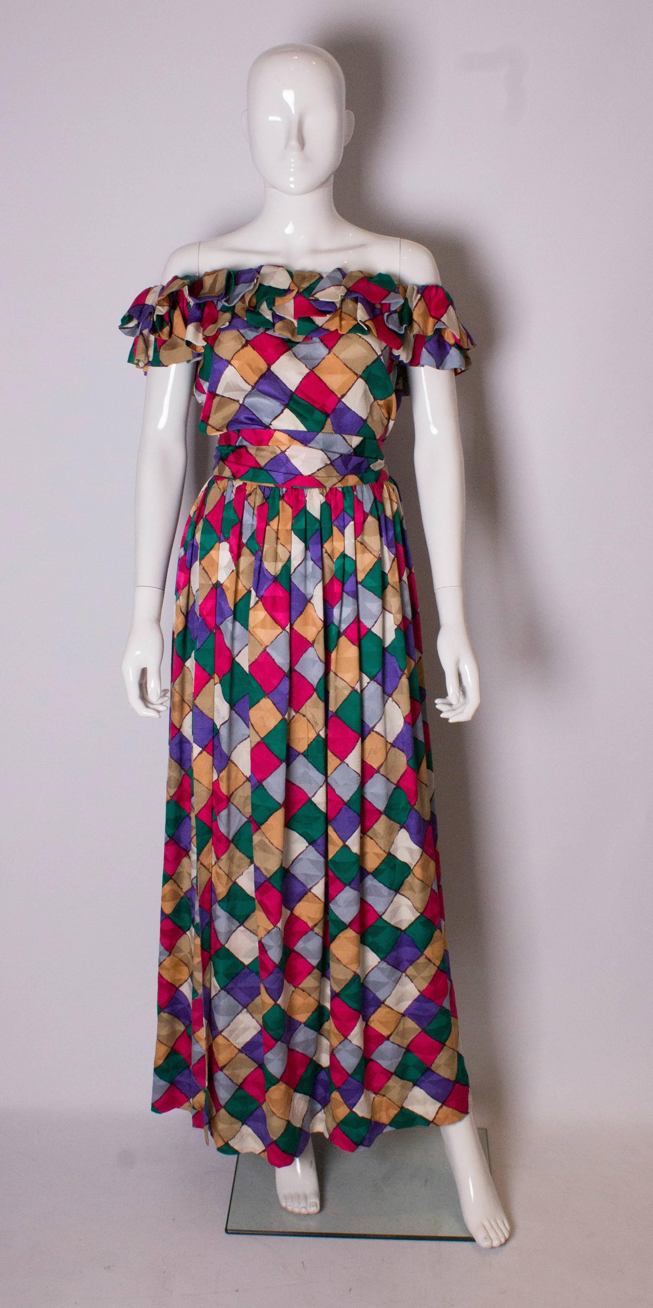 A colourful couture outfit by Andrea Oddicini. The skirt has a slight wrap over with gathering at the waist.  The fabric is a multi coloured textured silk with a diamond design. The matching top can be worn off the shoulder and has two rows of