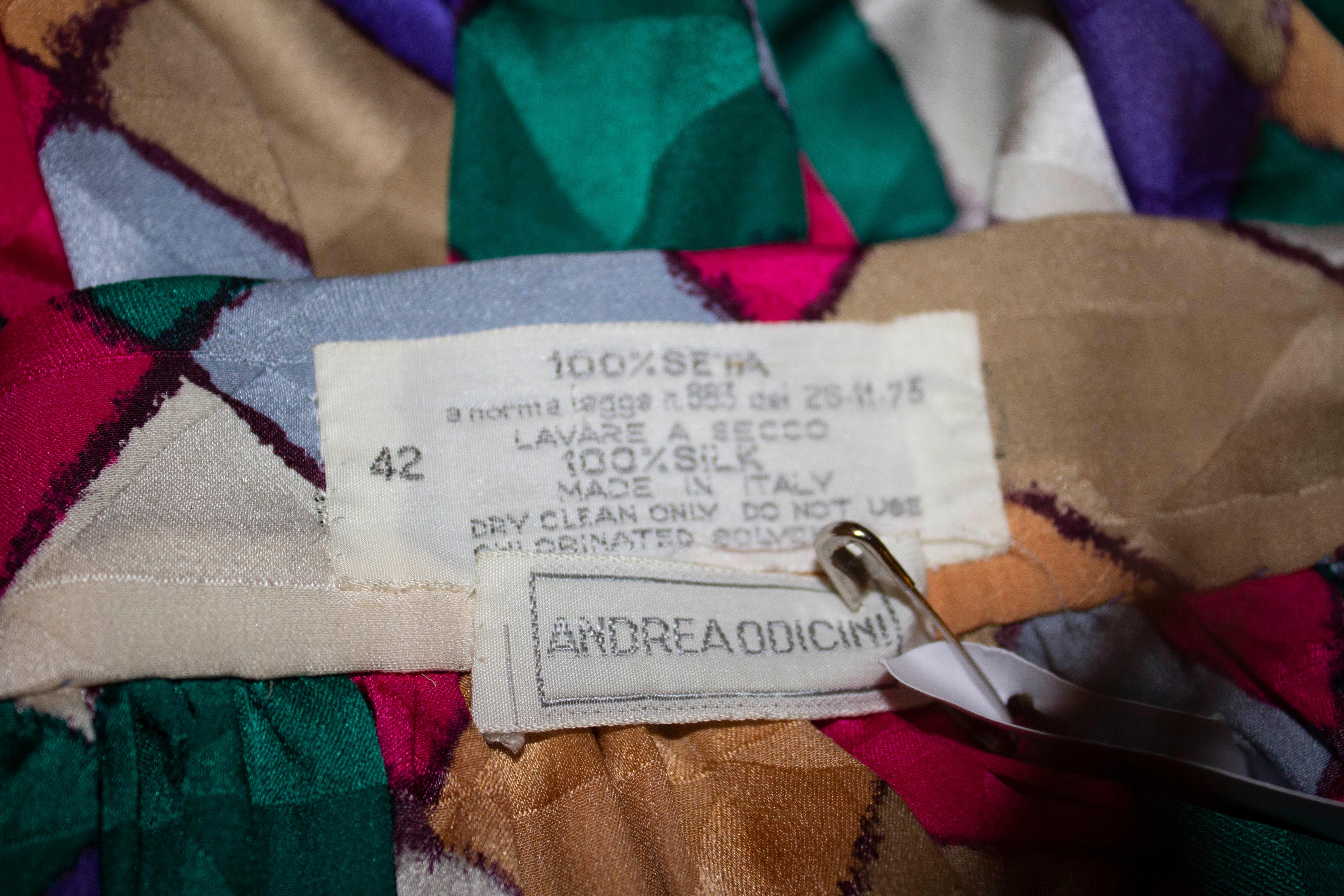 Une merveilleuse et colorée jupe portefeuille vintage en soie d'Andrea Odiccini. La jupe est disponible dans une multitude de couleurs, avec des fronces à la taille et un ourlet de 1 1/2''. 
Mesures : taille 26'', longueur 43'' ; l'écharpe assortie