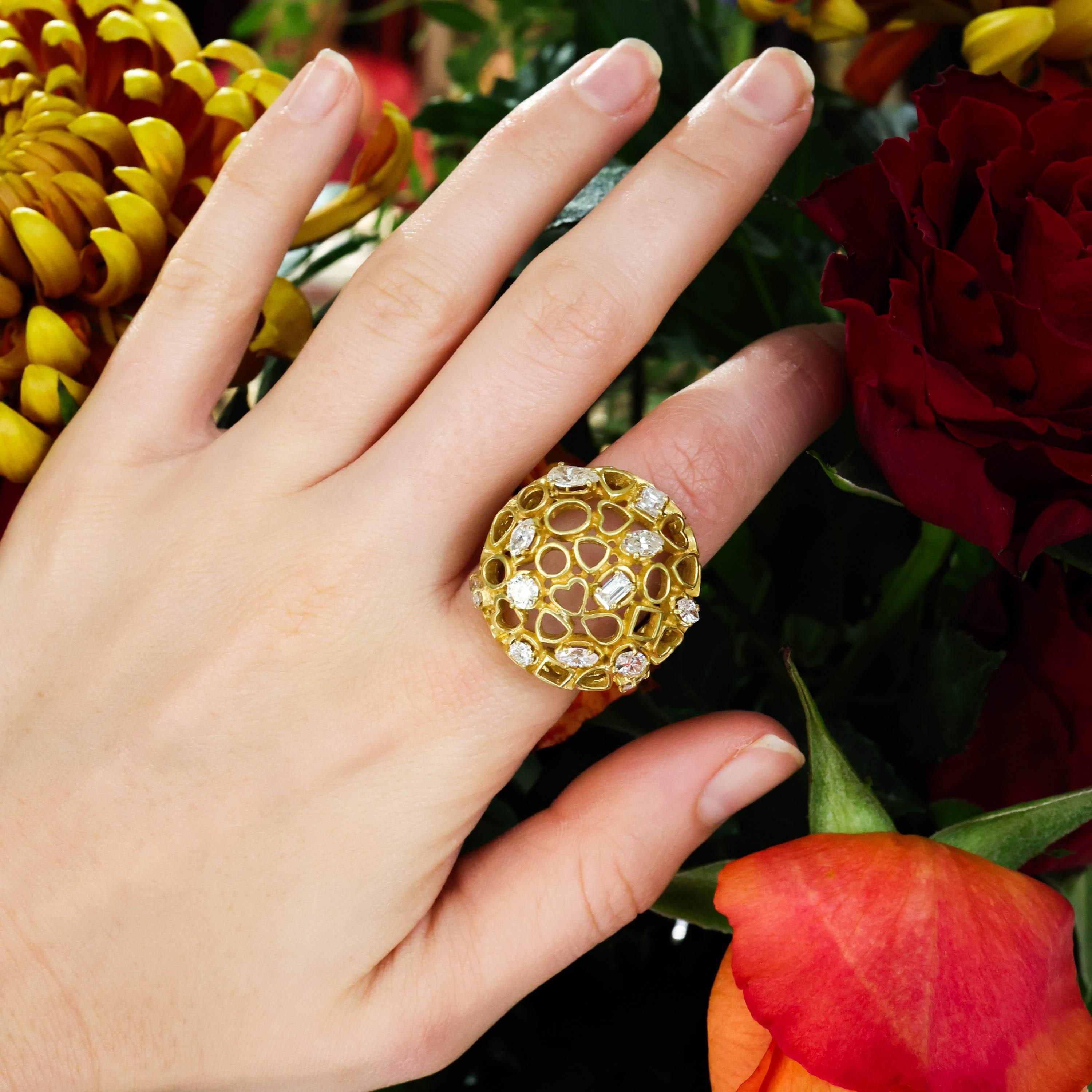 A vintage Andrew Grima diamond and gold bombé ring, composed of an openwork dome of hearts, squares, drops, triangles and circles, randomly set with marquise, oval, baguette, pear and round brilliant-cut diamonds, on a tapered wide band shank,