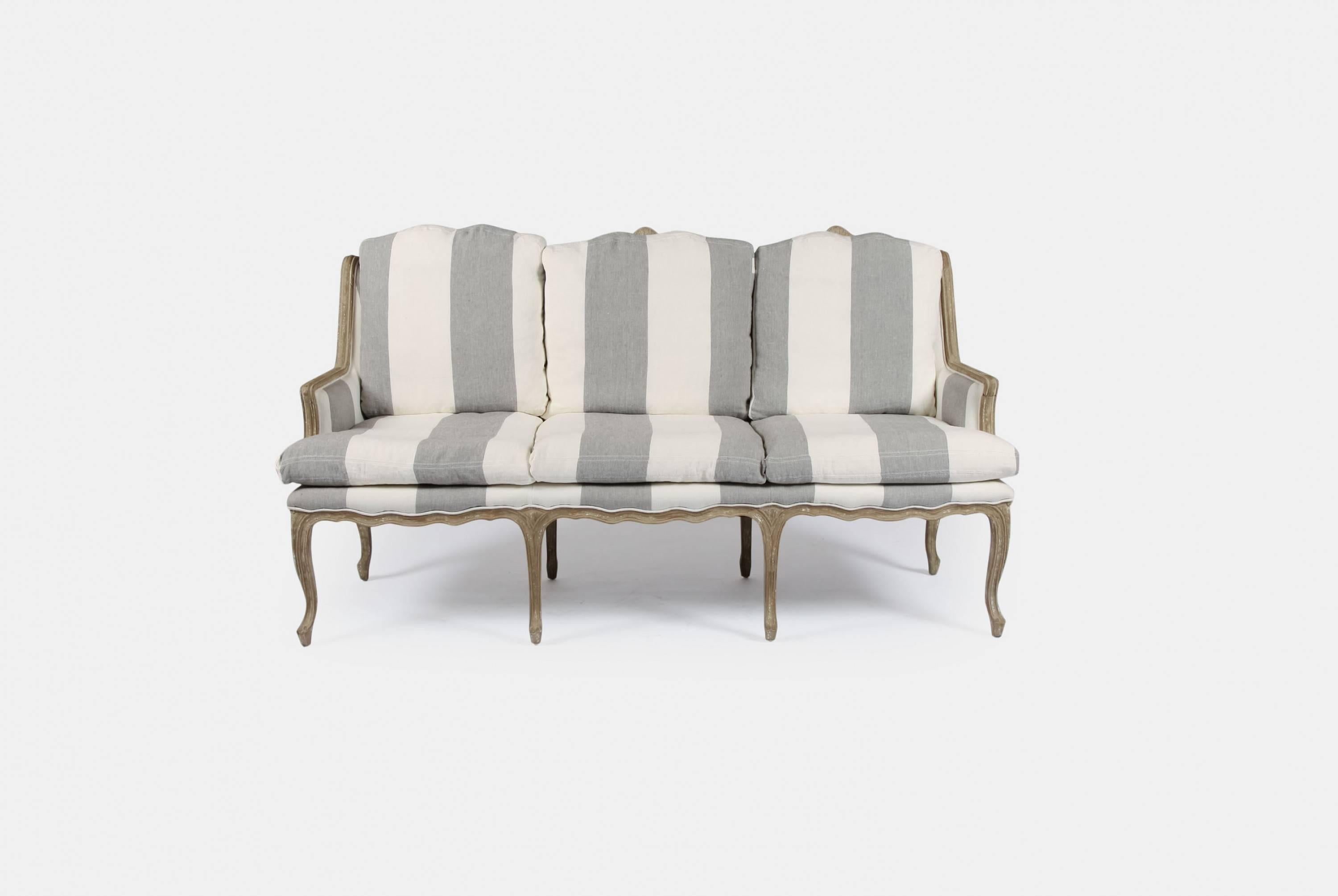 A stripe linen upholstered three-seat settee by Andrew Martin.

Since 1978, Andrew Martin has been at the forefront of global design from his base in London, United Kingdom. His aesthetic is neither defined by a single taste nor confined by a