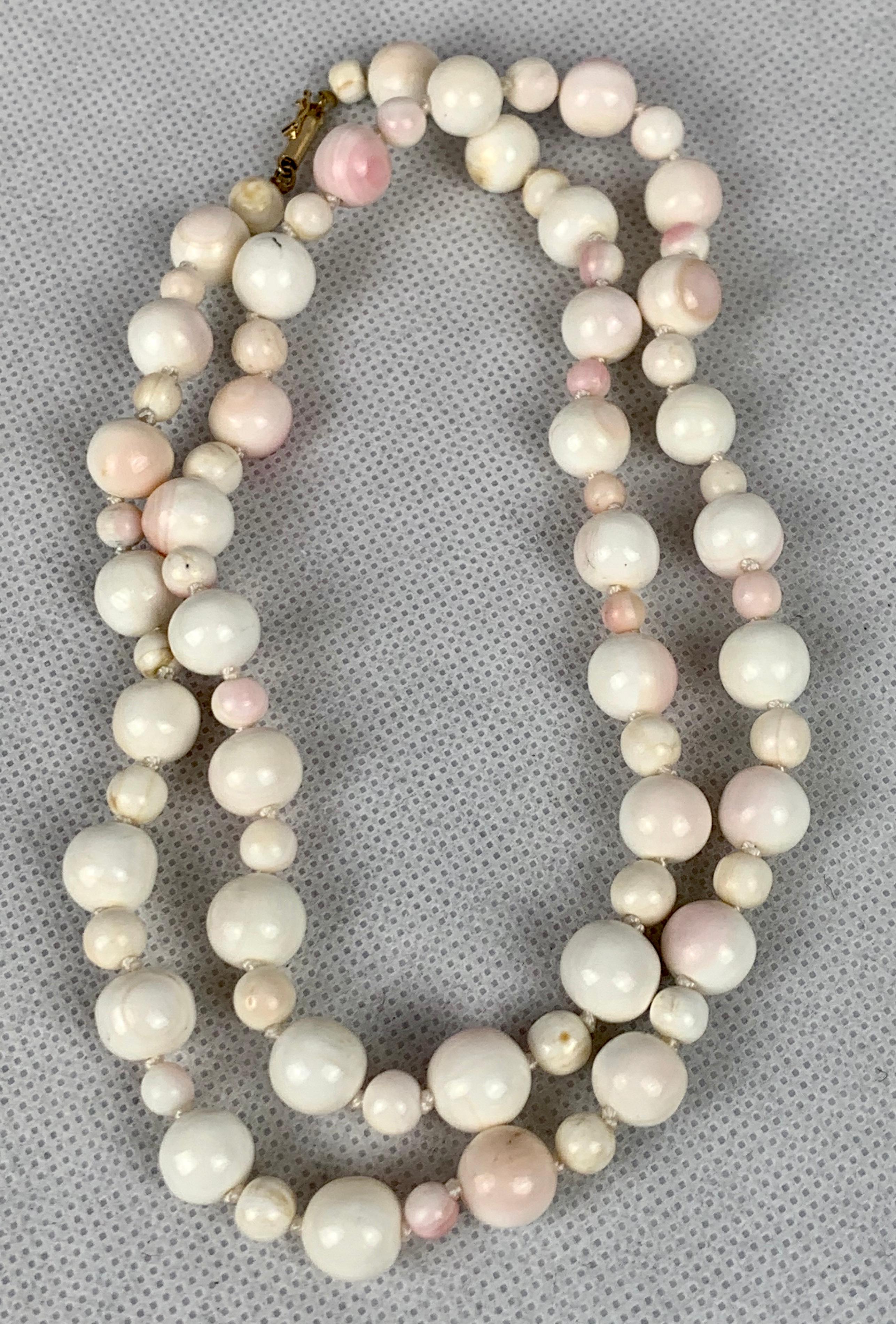 Vintage angel skin coral beaded necklace newly hand knotted on silk and freshly polished.  The design is a large and small bead in alternating order.  The clasp is a 14k yellow gold barrel clasp.   