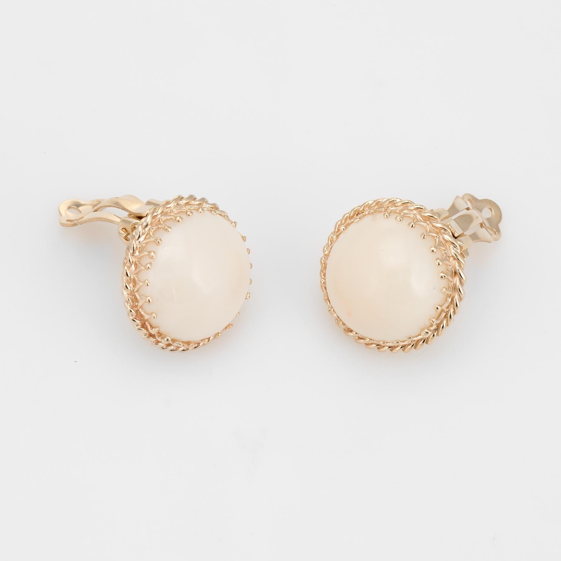 Finely detailed pair of vintage angel skin coral clip earrings (circa 1950s to 1960s), crafted in 14k yellow gold. 

Cabochon cut angel skin coral measures 15mm each - 9 carats each (18 carats total estimated weight). The coral is in excellent