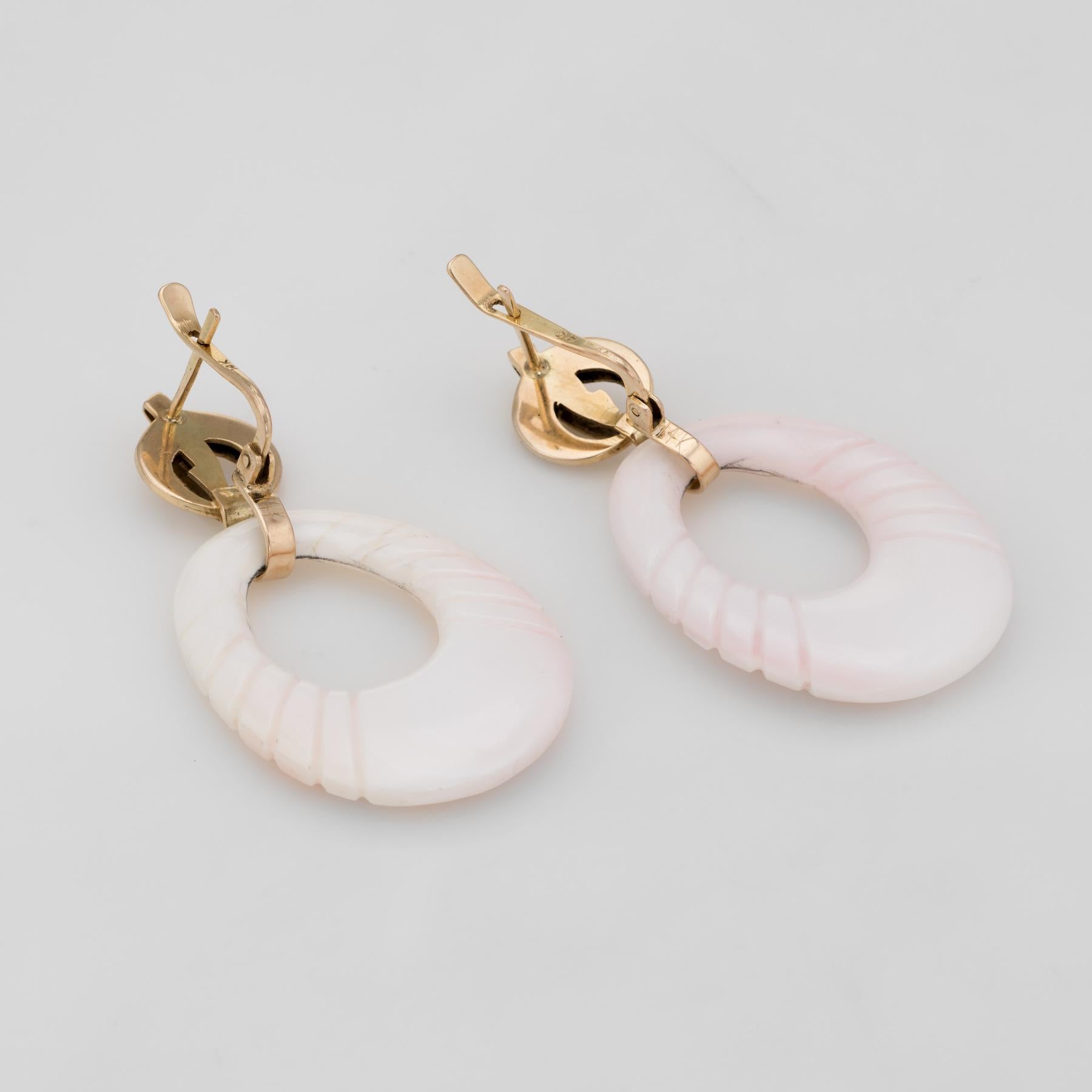 Finely detailed pair of vintage angel skin coral earrings (circa 1960s), crafted in 14k yellow gold. 

Two pieces of angel skin coral measure 38mm x 27mm. The coral features a graduated ridged design on both sides of the coral.   

The earrings make