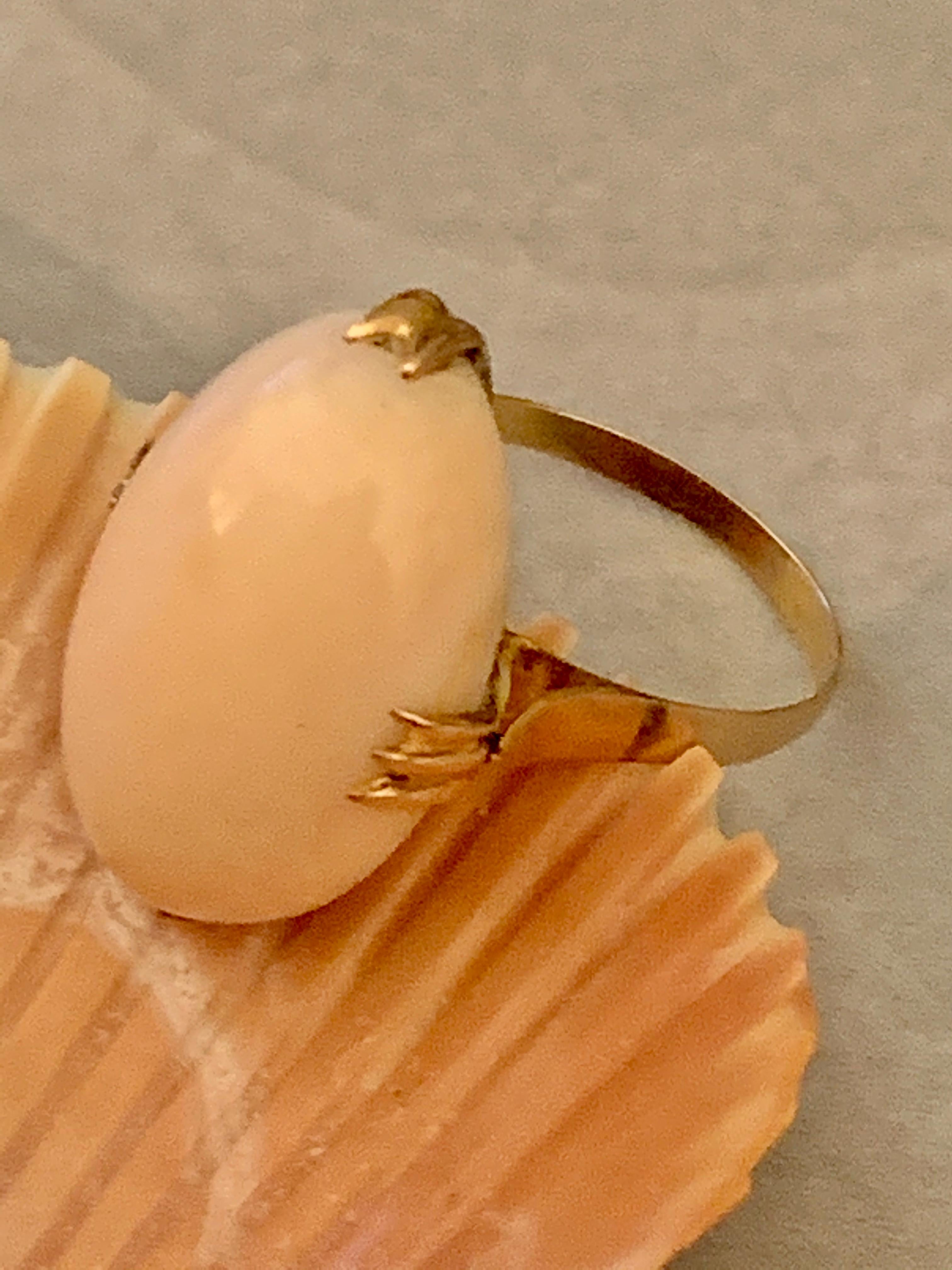 This beautiful ring features a 24 x 15mm oval, cabochon Angel Skin Coral.  It is set in 14 karat yellow Gold.

Size: 8
Weight: 7.3 grams
