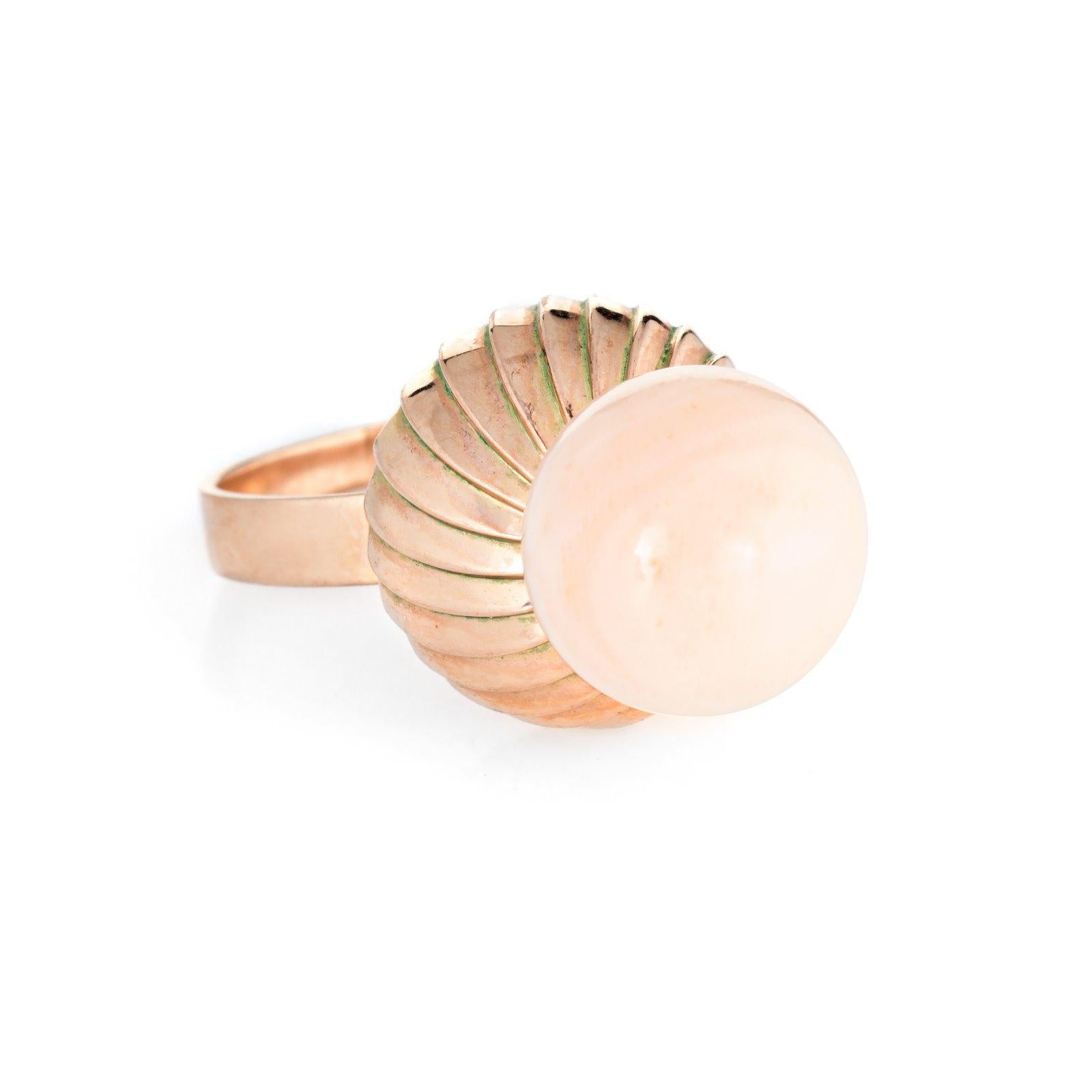Stylish vintage angel skin coral ring (circa 1960s to 1970s) crafted in 14 karat rose gold. 

Angel skin coral measures 12mm (in excellent condition and free of cracks or chips). 

The coral is perched on top of a high rising textured mount that