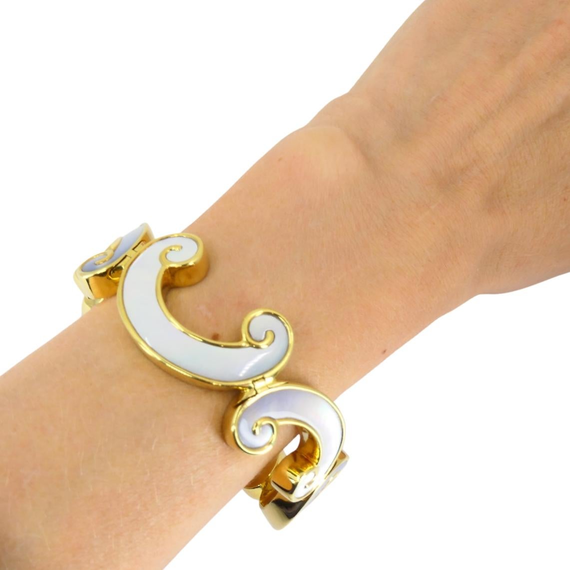 Questo braccialetto vintage di Angela Cummings mette in evidenza lo stile caratteristico della stilista, che combina forme organiche e materiali di lusso. Realizzato in oro giallo 18 carati, il bracciale presenta una serie di motivi a onda che