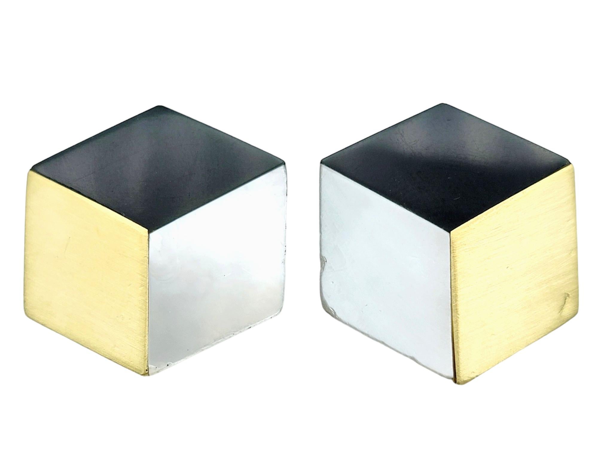 This vintage pair of Angela Cummings clip-on earrings in 18 karat yellow gold exhibits a captivating blend of sophistication and artistry. Fashioned into a hexagonal shape, each earring features distinct sections adorned with onyx, lustrous gold,