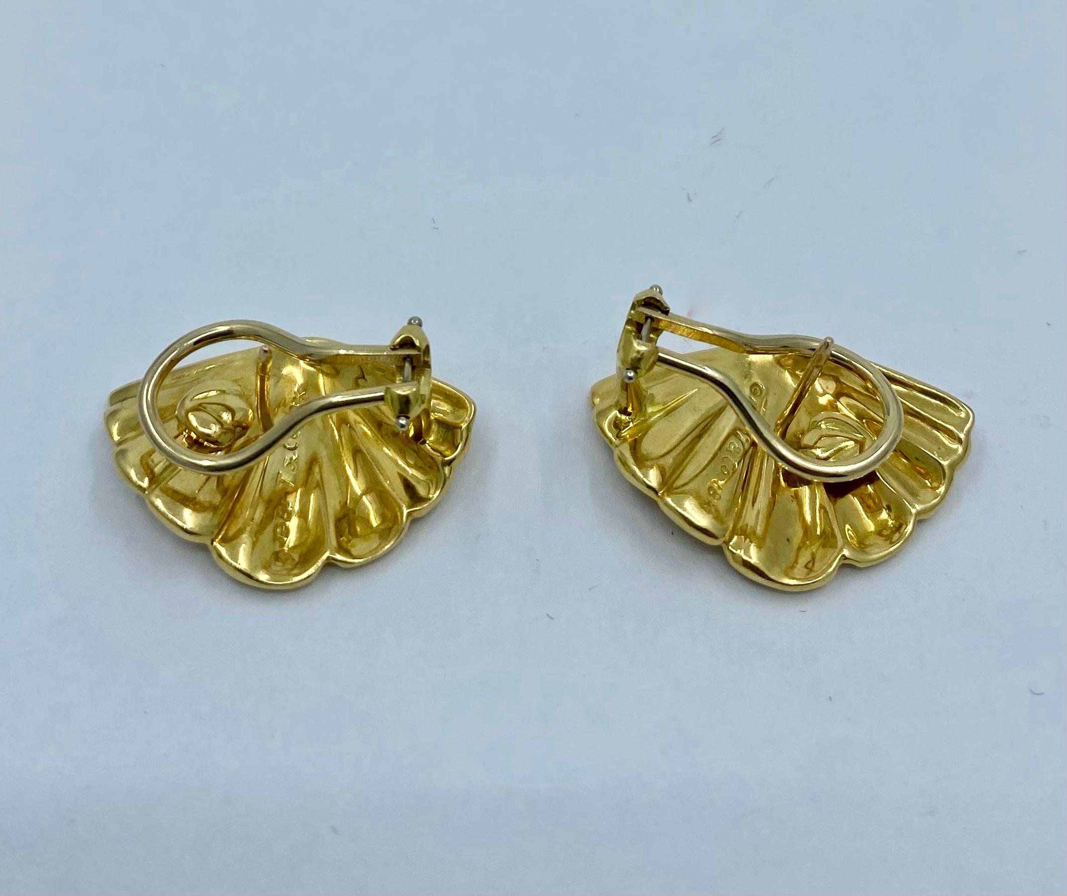 Designer: Tiffany & Co. 
Materials: 18K Yellow Gold
Weight: 13.7 grams
Measurement: 1 inches long and 5/8 inches wide
Hallmarks: 1981 T & Co. 18K

A pair of Tiffany & Co. 18k gold scallop shell earrings.
Tiffany has been applied a seashell motif for