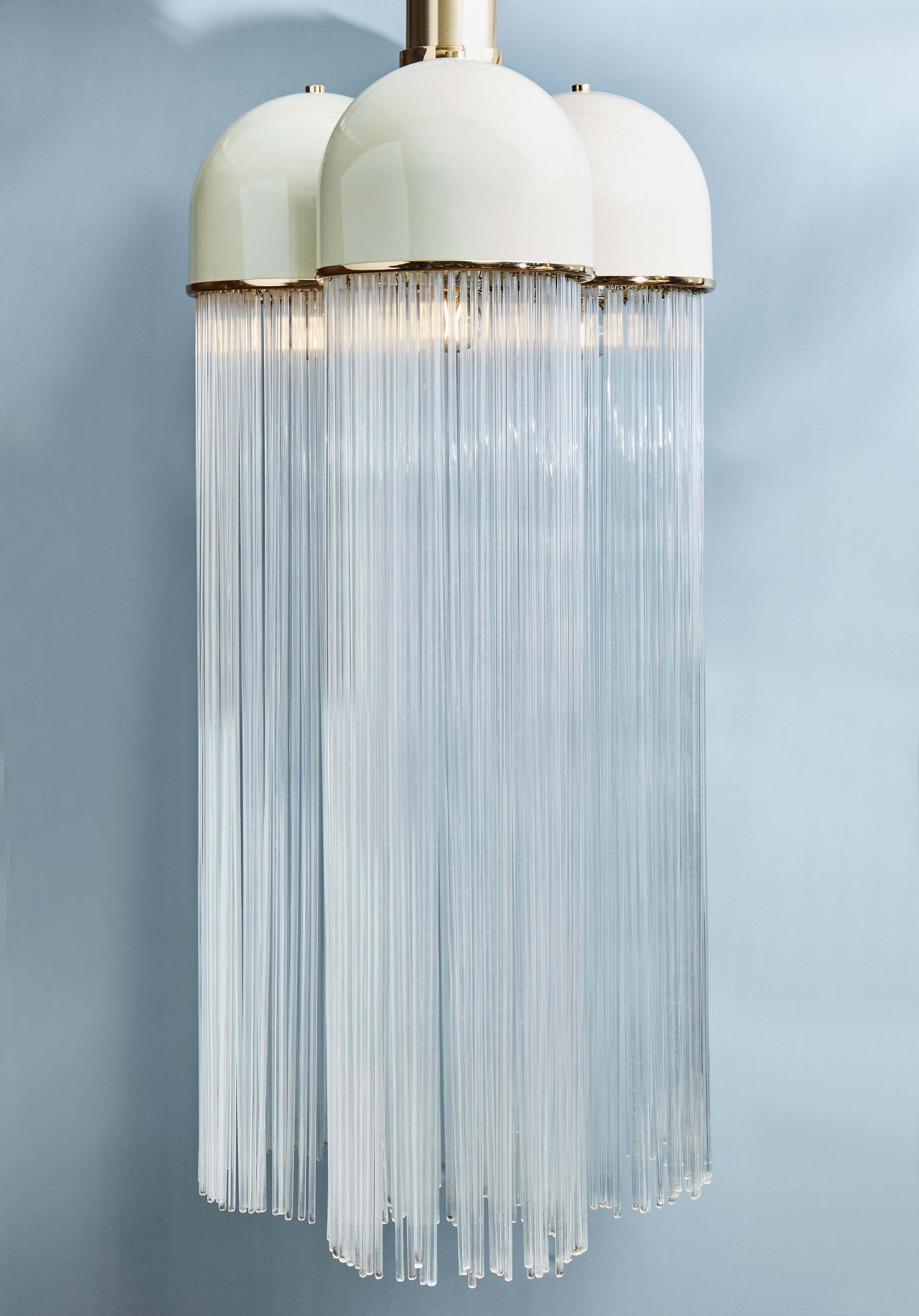 Coming from the archives of the renown Italian lights maker Esperia is this chandelier made of three domes in white enameled metal, brass details and tens of thin glass rods hanging, designed by Angelo Brotto in 1978 and produced in 1979.

One