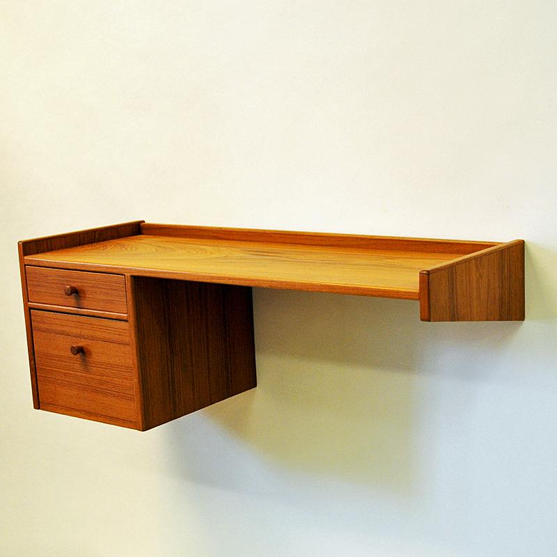 Decorative angle shaped teak shelf - produced in Sweden in the 1950s. A shelf for any wall in the hallway, livingroom, bedroom or babyroom maybe?....
With a smaller and a larger drawer underneath. Teak knob handle and listings all around. Good