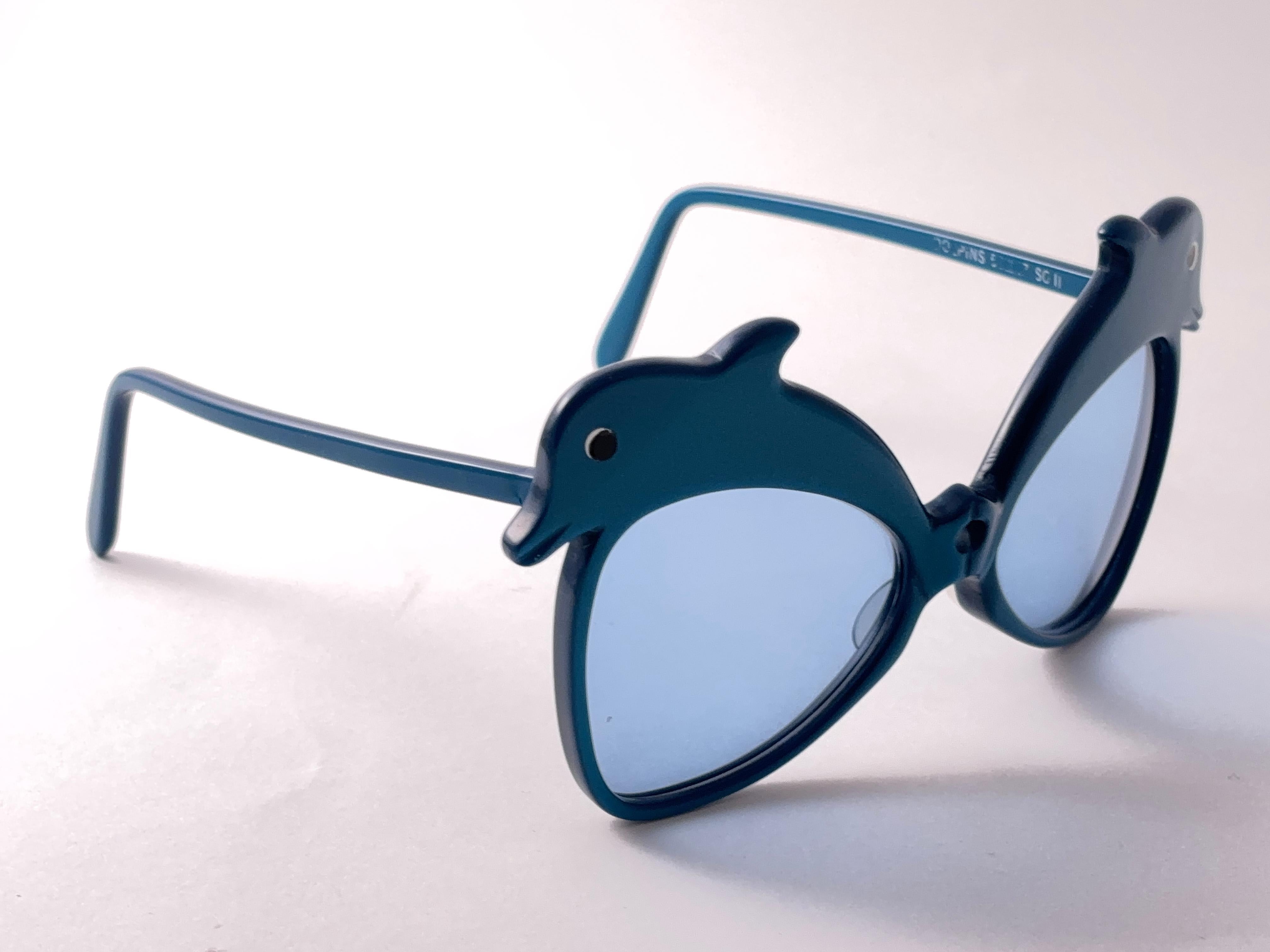 Occhiali da sole altamente collezionabili firmati da Anglo American Optical.

Nuovi occhiali angloamericani d'epoca  Montatura blu ornata da due simpatici delfini capricciosi Occhiali da sole con lenti azzurre 1970's Made In England.

Questo
