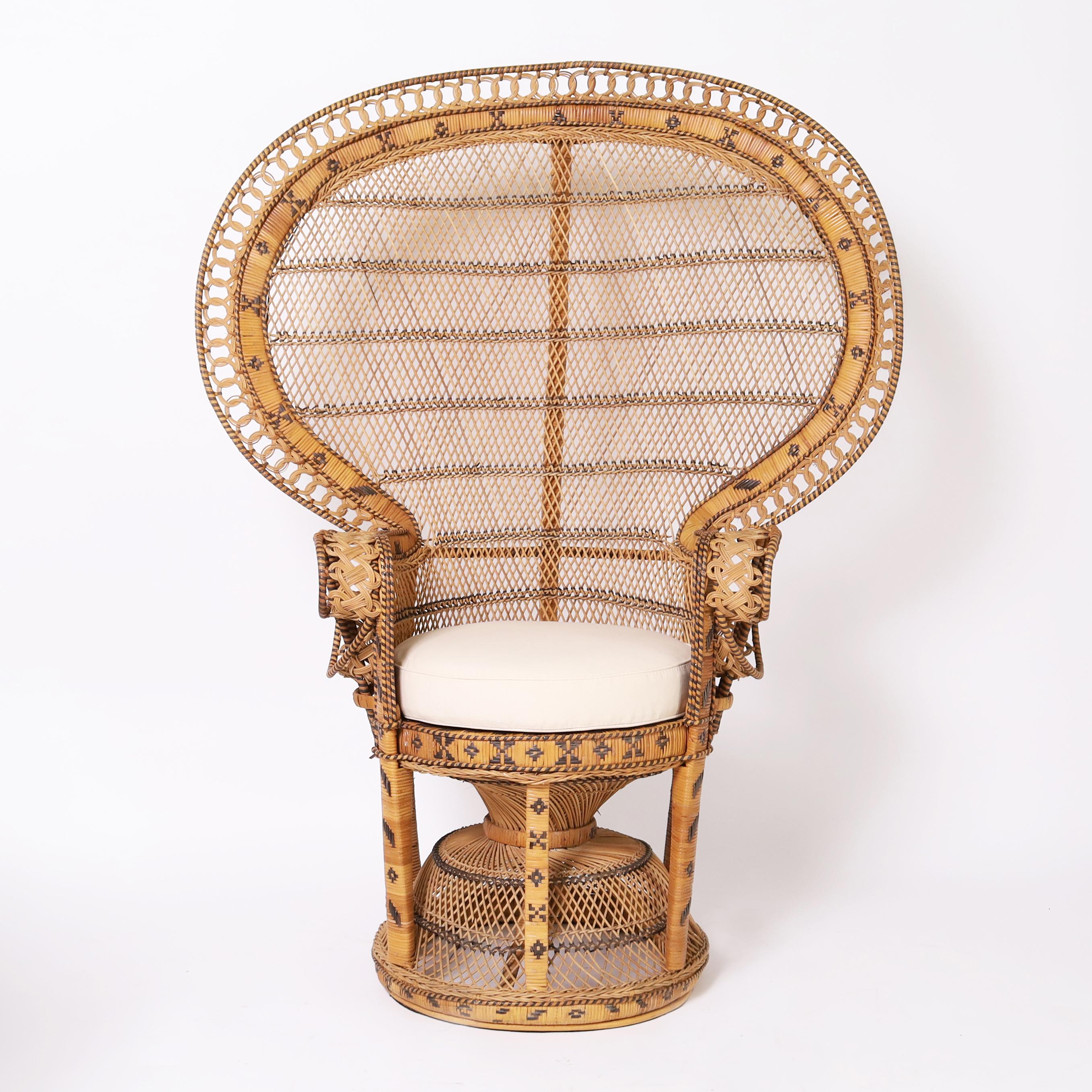 British Colonial style Anglo Indian peacock chair and matching ottoman handcrafted in classic form with wicker and rattan having caned seats and painted geometric designs. As seen in the last photo of the listing, we have a similar set also