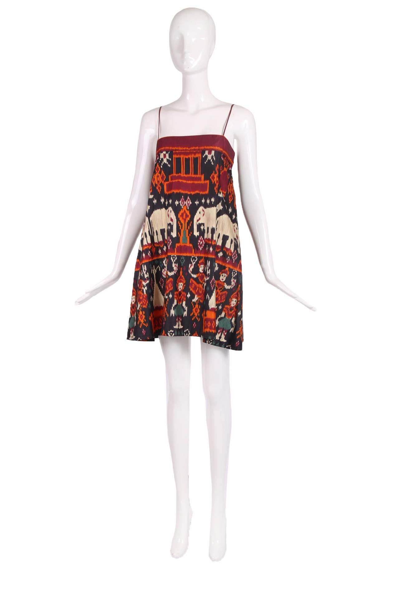 Vintage Anne Klein from the Donna Karan era mini dress w/Ikat-style print featuring elephants and humans wearing hats standing under a temple.Shoulder ties fasten at the back by means of hook and eye closures. Size 4. No fabric tag but feels like