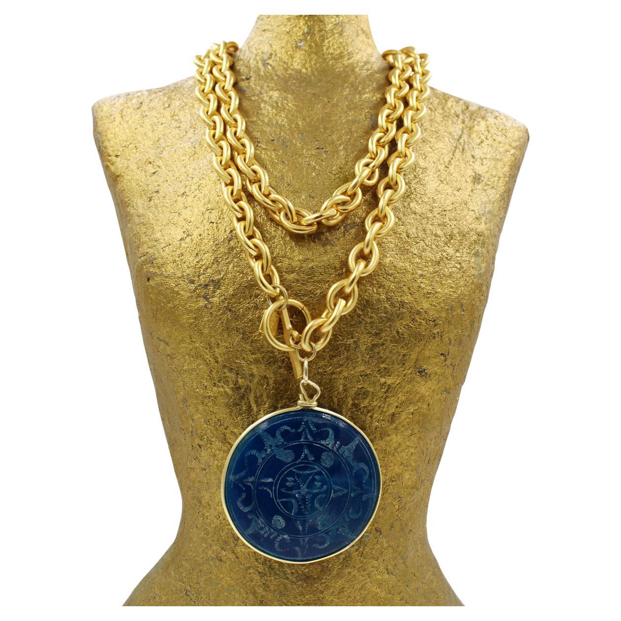 Vintage Anne Klein collier à bascule avec disque bleu.   Peut être porté en double autour du cou comme indiqué. Il s'agit d'une chaîne à maillons en or mat avec un grand disque rond bleu. Le disque a un côté mat et un côté avec des gravures bleues