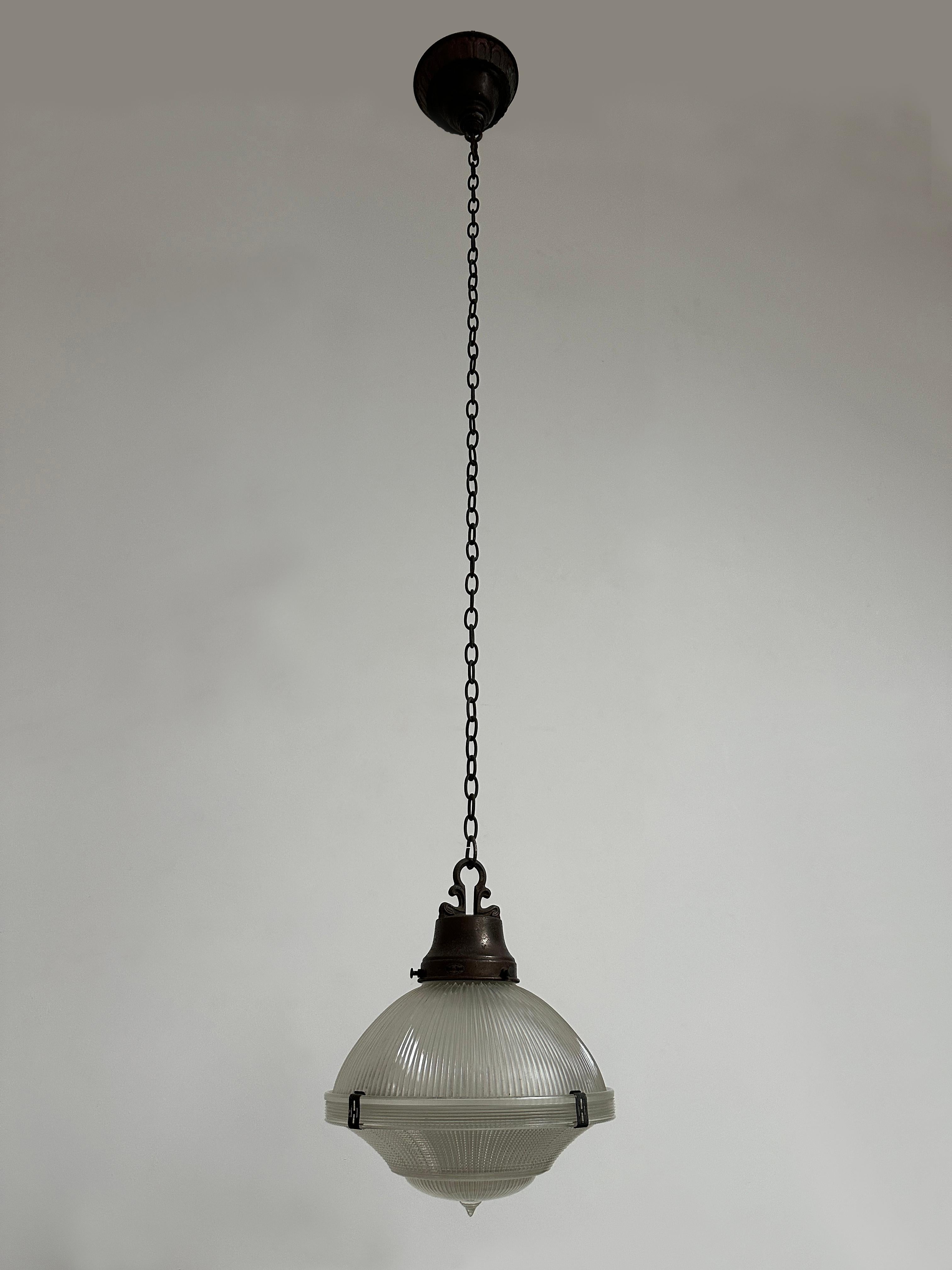 - Maravilloso colgante de techo Holophane de cobre en tres partes, con cadena y rosetón, estadounidense, circa 1930.
- El colgante está formado por dos secciones de cristal prismático unidas por cuatro pinzas de Holofane originales; el plato de